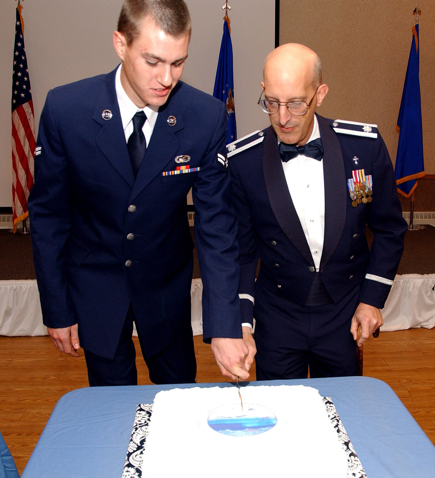 Airman 1st Class Willard Grande, left, and Lieutenant Colonel David Terrinoni Wing Chaplain, right, cut the 61st birthday cake at the 2008 Air Force Gala at Eielson Air Force Base, Alaska, Sept. 26, 2008. It is tradition that the oldest Air Force officer cut the birthday cake with the youngest enlisted Air Force member attending the celebration. (U.S. Air Force photo by Airman Laura Max)                                  