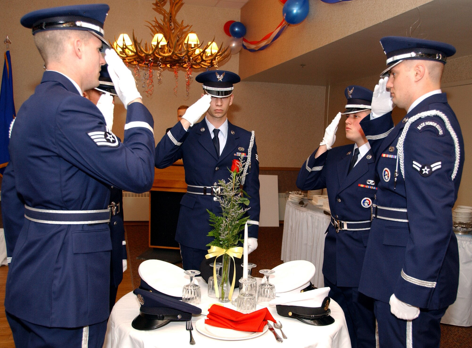 The honor guard salutes in remembrance of the fallen soldiers and Prisoners of War from all military branches during  the 2008 Air Force Gala  at Eielson Air Force Base, Alaska, Sept. 26, 2008. The empty table is set for fallen soldiers and POWs. (U.S. Air Force photo by Airman Laura Max)                               