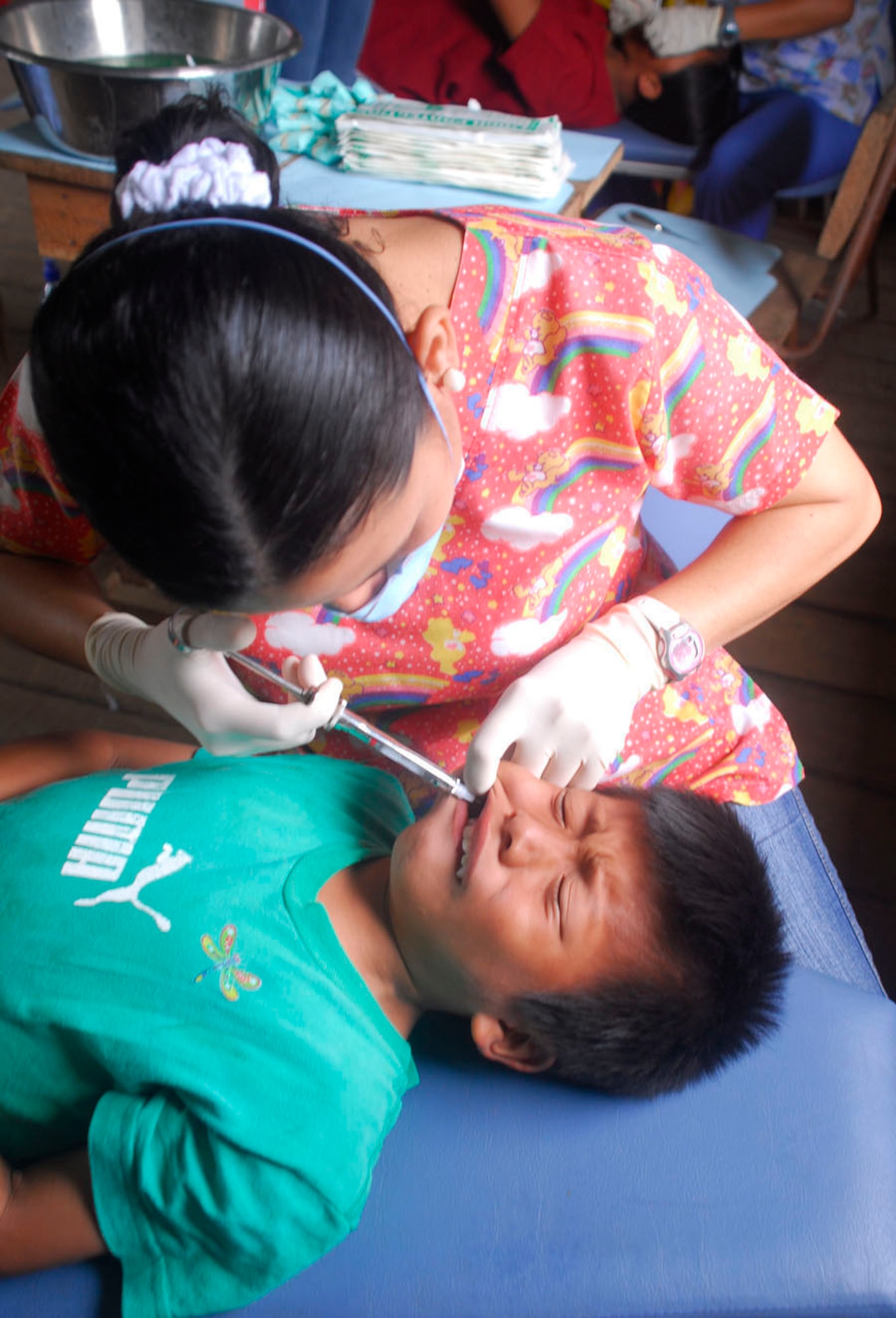 ALTO DE CARONA, Costa Rica - A dentist with the Costa Rican Social Security Health Services Administration begins the steps to remove a tooth from a young boy. The medical care provided on this medical readiness exercise by the United States and Costa Rica isn't measured by how many people, but by the impact of the service provided. (U.S. Air Force photo by Staff Sgt. Joel Mease)