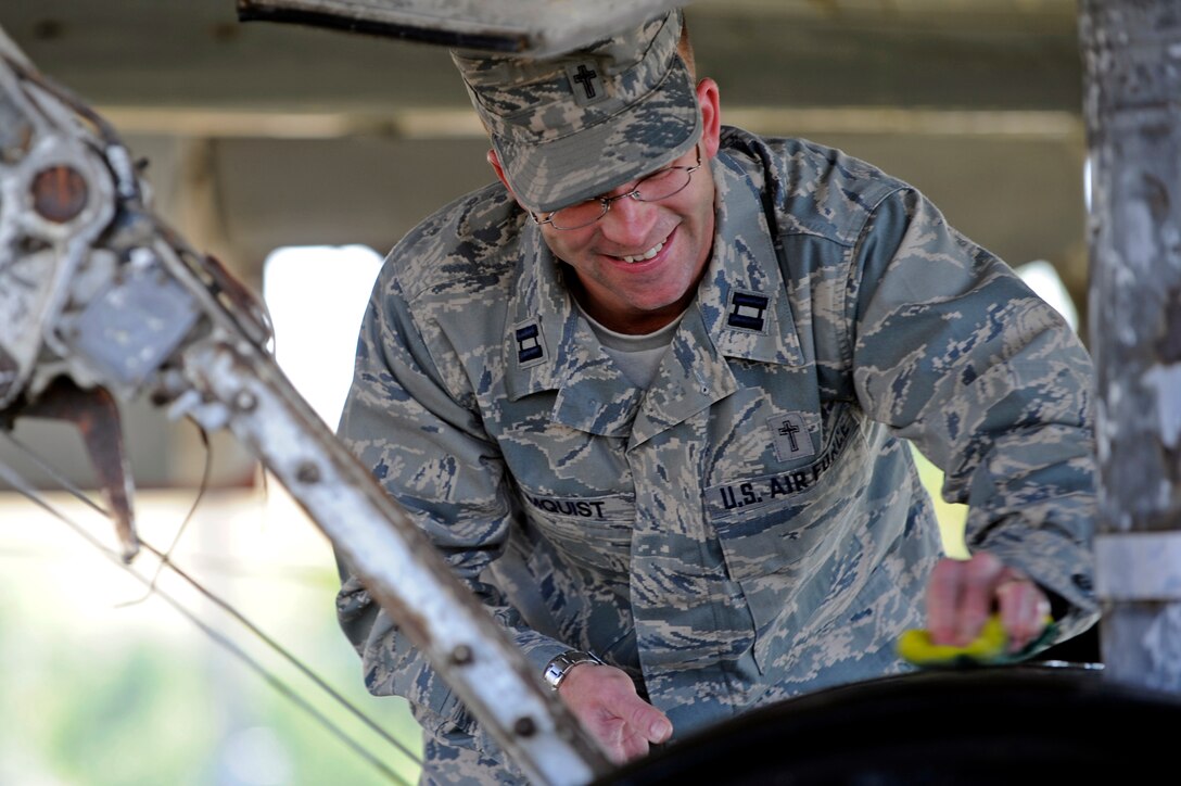 Capt. Rolf Holmquist, 28th Bomb Wing chaplain, cleans the tires of a C-54 "Skymaster" aircraft as part of the Adopt-a-Plane program at the South Dakota Air and Space Museum, Sept. 29.  The project allows Airmen to learn about their heritage as well as preserve it. (U.S. Air Force photo/Airman Matthew Flynn)