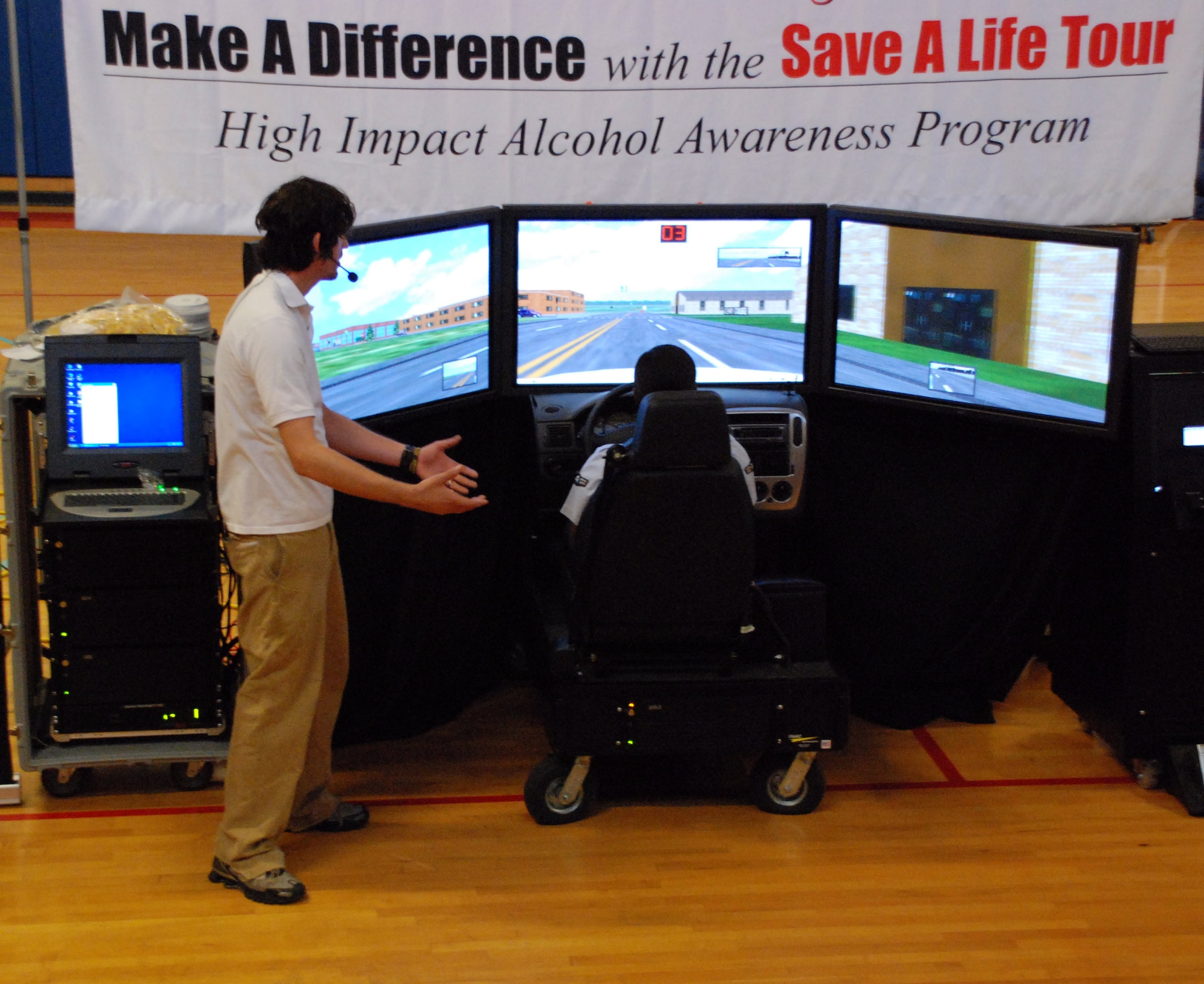 LAUGHLIN AIR FORCE BASE, Texas -- Brian Beldyga, "Save a Life" anti-drinking and driving program host, instructs Airman 1st Class Tammy Marshall on the use of the program's drunk driving simulator during a presentation in Laughlin's "old gym' Sept. 29.  (U.S. Air Force photo)