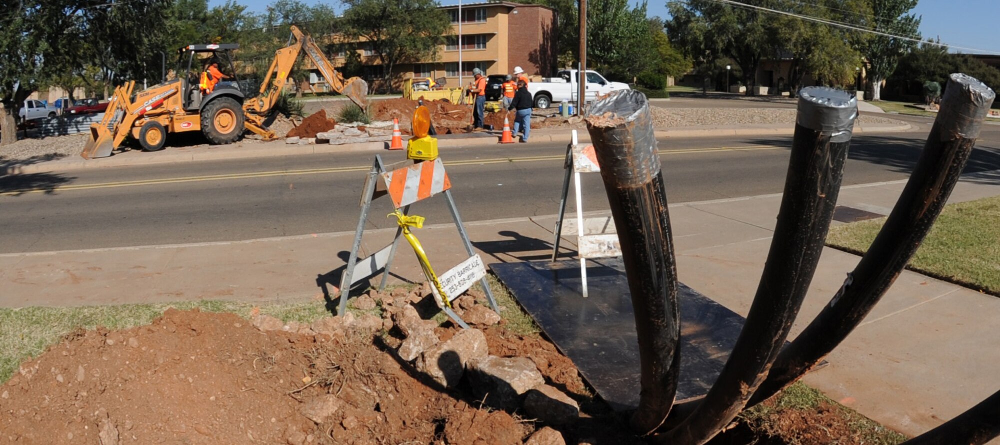 CANNON AIR FORCE BASE, N.M.--  A work crew with General Dynamics Construction Company installs additional fiber optic cables in front of the Pecos Trail Dining Facility Sept. 30 to provide redundancy to Cannon's communication system lines. (U.S. Air Force photo/Airman Maynelinne De La Cruz)