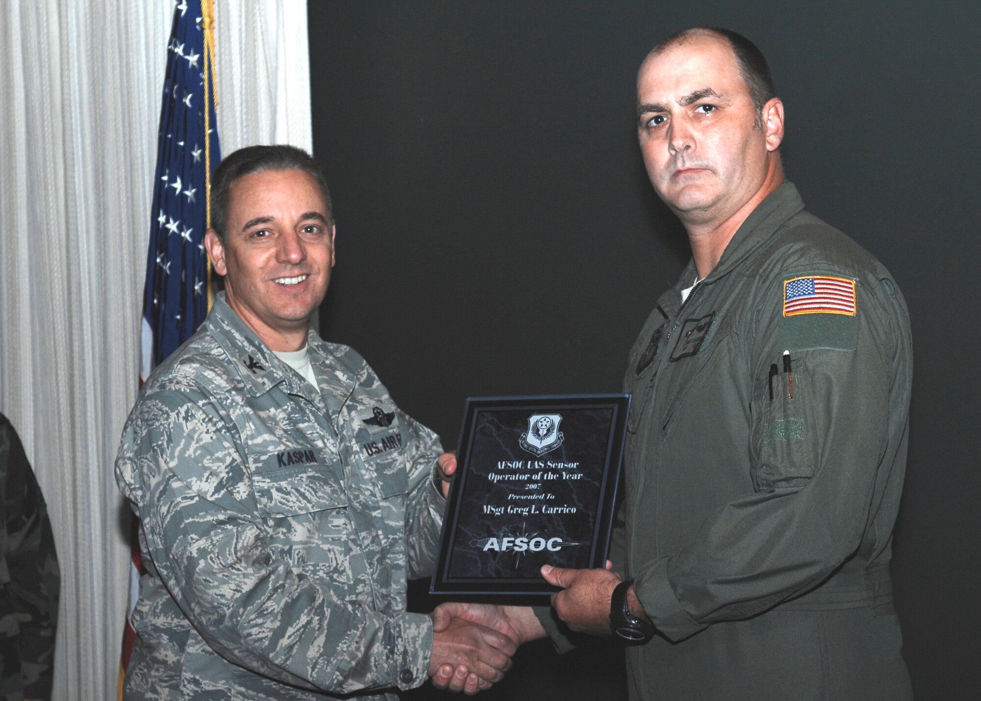 CANNON AIR FORCE BASE, N.M.- Master Sgt. Greg Carrico, 3rd Special Operations Squadron, receives the first-ever Air Force Special Operations Command Unmanned Aerial System Sensor Operator of the Year Award from Col. Hans Kaspar, 27th Special Operations Wing vice commander. Sergeant Carrico received the award September 30 at the weekly wing staff meeting. (U.S. Air Force photo/Airman 1st Class Danielle Martin)