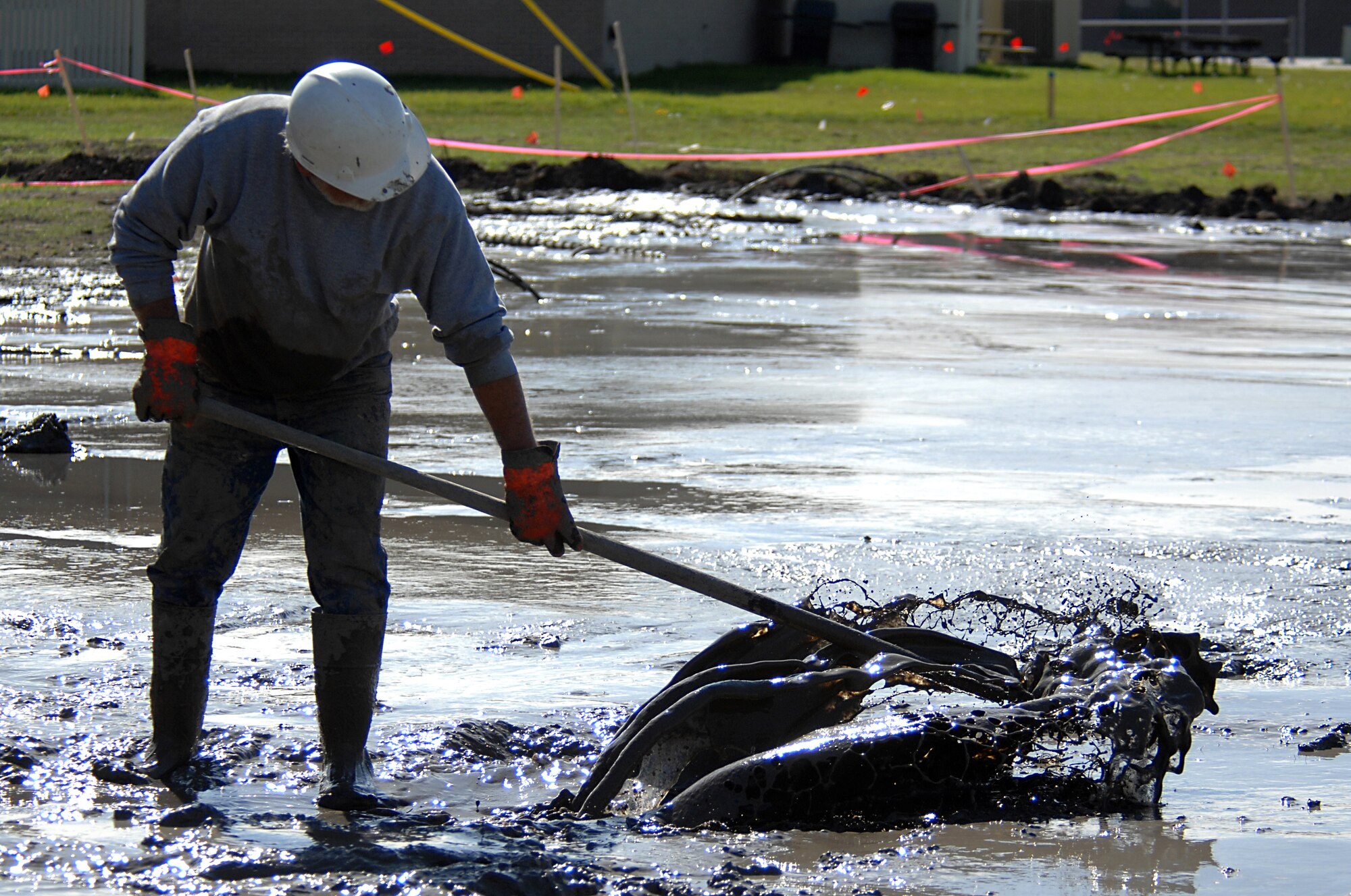 MINOT AIR FORCE BASE, N.D. – Richard Kazmaiez, a worker for RNP Installation and Drilling, pushes mud away from a seismic drilling rig here at Sept. 24.  Kazmaiez and his team are installing a geothermal heating system in the 5th Bomb Wing Headquarters building. This new system, which replaces the old hot water boiler system, will save the Air Force around 30 to 70 percent in heating costs, and 20 to 50 percent in cooling costs. (U.S. Air Force photo by Senior Airman Kelly Timney) 