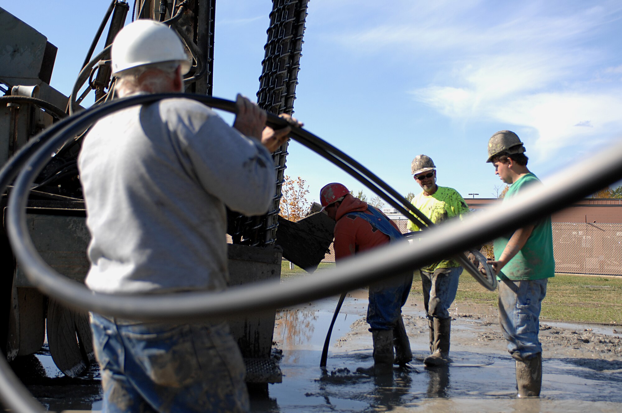 MINOT AIR FORCE BASE, N.D. – Richard Kazmaiez, a worker for RNP Installation and Drilling, helps support the weight of the lines for the geothermal heating system while his co-workers push the line into the ground here Sept. 24. The 5th Bomb Wing Headquarters building is replacing the old hot water boiler system with a geothermal heating system, which will save the Air Force around 30-70 percent in heating costs, and 20-50 percent in cooling costs. (U.S. Air Force photo by Senior Airman Kelly Timney) 