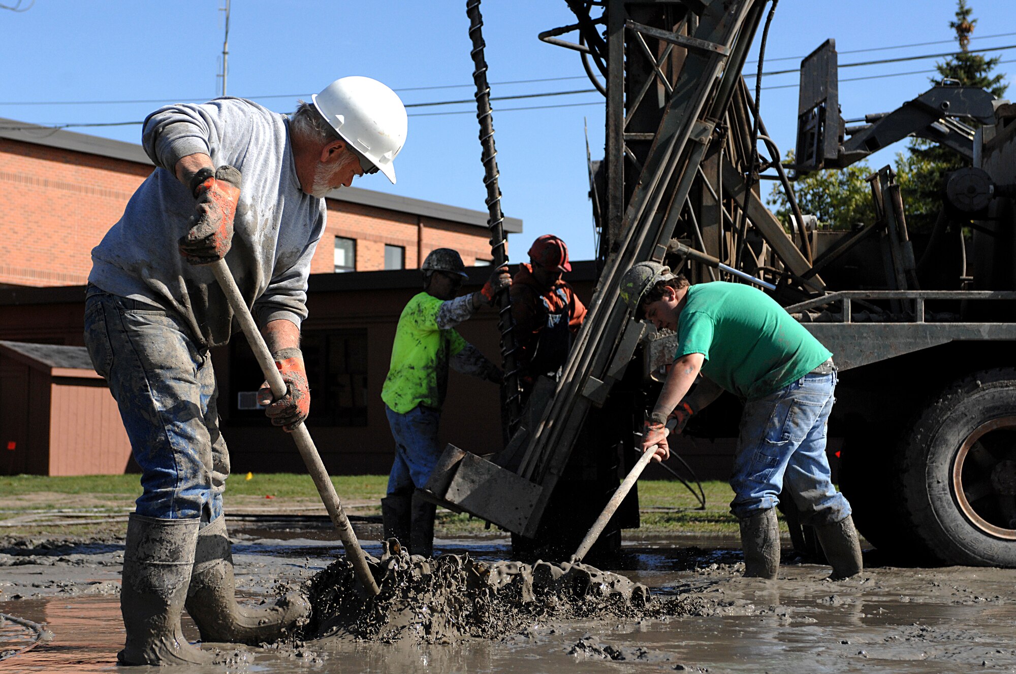 MINOT AIR FORCE BASE, N.D. – Richard Kazmaiez, RNP Installation and Drilling, rakes mud away from a seismic drilling rig while he and his team install a geothermal heating system in the 5th Bomb Wing Headquarters building here Sept. 24. This new system, which replaces the old hot water boiler system, will save the Air Force around 30 to 70 percent in heating costs, and 20 to 50 percent in cooling costs. (U.S. Air Force photo by Senior Airman Kelly Timney)  