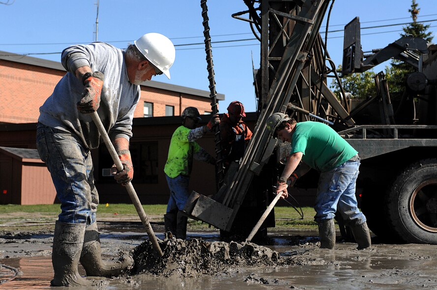 MINOT AIR FORCE BASE, N.D. – Richard Kazmaiez, RNP Installation and Drilling, rakes mud away from a seismic drilling rig while he and his team install a geothermal heating system in the 5th Bomb Wing Headquarters building here Sept. 24. This new system, which replaces the old hot water boiler system, will save the Air Force around 30 to 70 percent in heating costs, and 20 to 50 percent in cooling costs. (U.S. Air Force photo by Senior Airman Kelly Timney)  