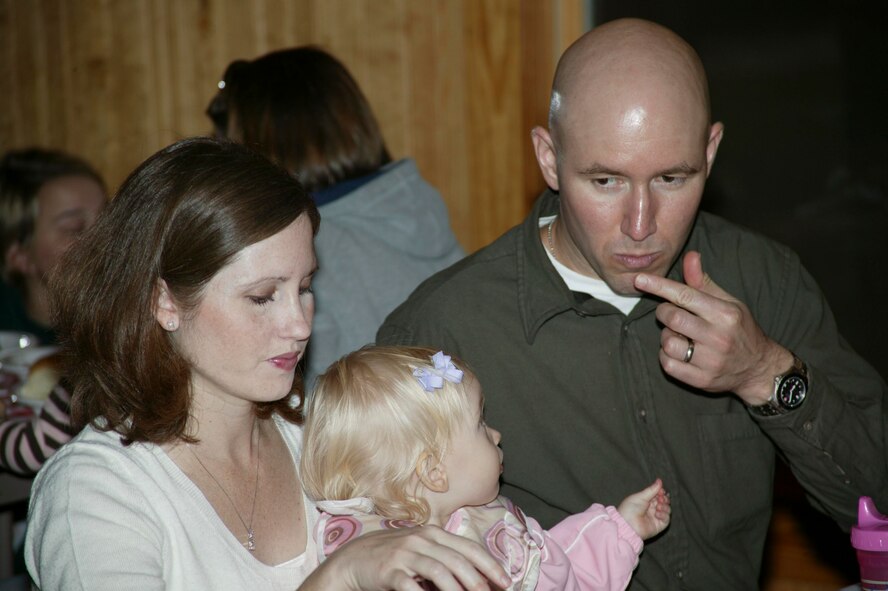SUMTER, S.C.-- Mary Wainwright, Army Capt. Ryan Wainwright and 16-month-old, Danielle Wainwright, sit together for dinner with fellow soldiers and families of the Army 4th Battlefield Coordination Detachment, at a farewell dinner held at the Carter Cabin Sept. 25. The 4th BCD is preparing to deploy as a unit next week to Southwest Asia for one year. (U.S. Air Force photo/Staff Sgt. Holly Brown)