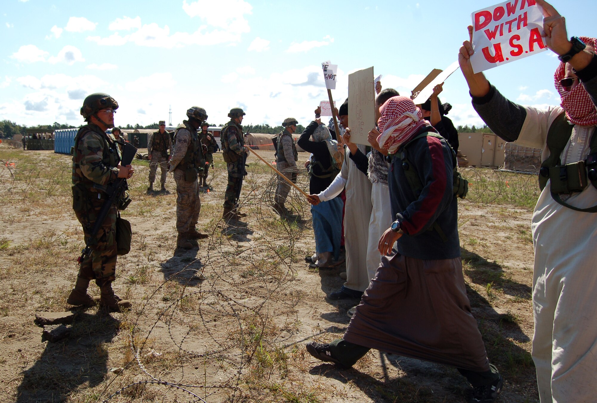 Airmen control protesters in the fictional country of Chimaera during a scenario for Air Force Exercise Eagle Flag 08-6 Sept. 23, 2008, at Naval Air Engineering Station Lakehurst, N.J.  The exercise is managed by the U.S. Air Force Expeditionary Center's 421st Combat Training Squadron and tests and trains Airmen in expeditionary combat support skills.  (U.S. Air Force Photo/Senior Airman Julius Delos Reyes)