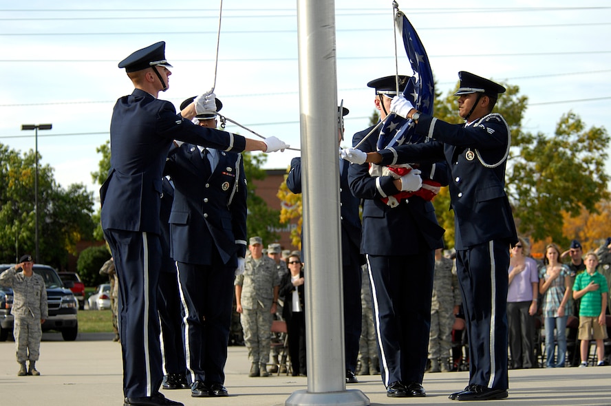 MINOT AIR FORCE BASE, N.D. –Airmen and guests stand at attention as members of the base honor guard fold the American flag during the POW/MIA Recognition Day retreat ceremony here Sept. 29. The ceremony was organized as a joint effort between the 5th Bomb Wing and 91st Missile Wing as a way to pay tribute to all prisoners of war and missing in action service-members, who have served, suffered and given their lives for our nation. (U.S. Air Force photo by Senior Airman Kelly Timney) 