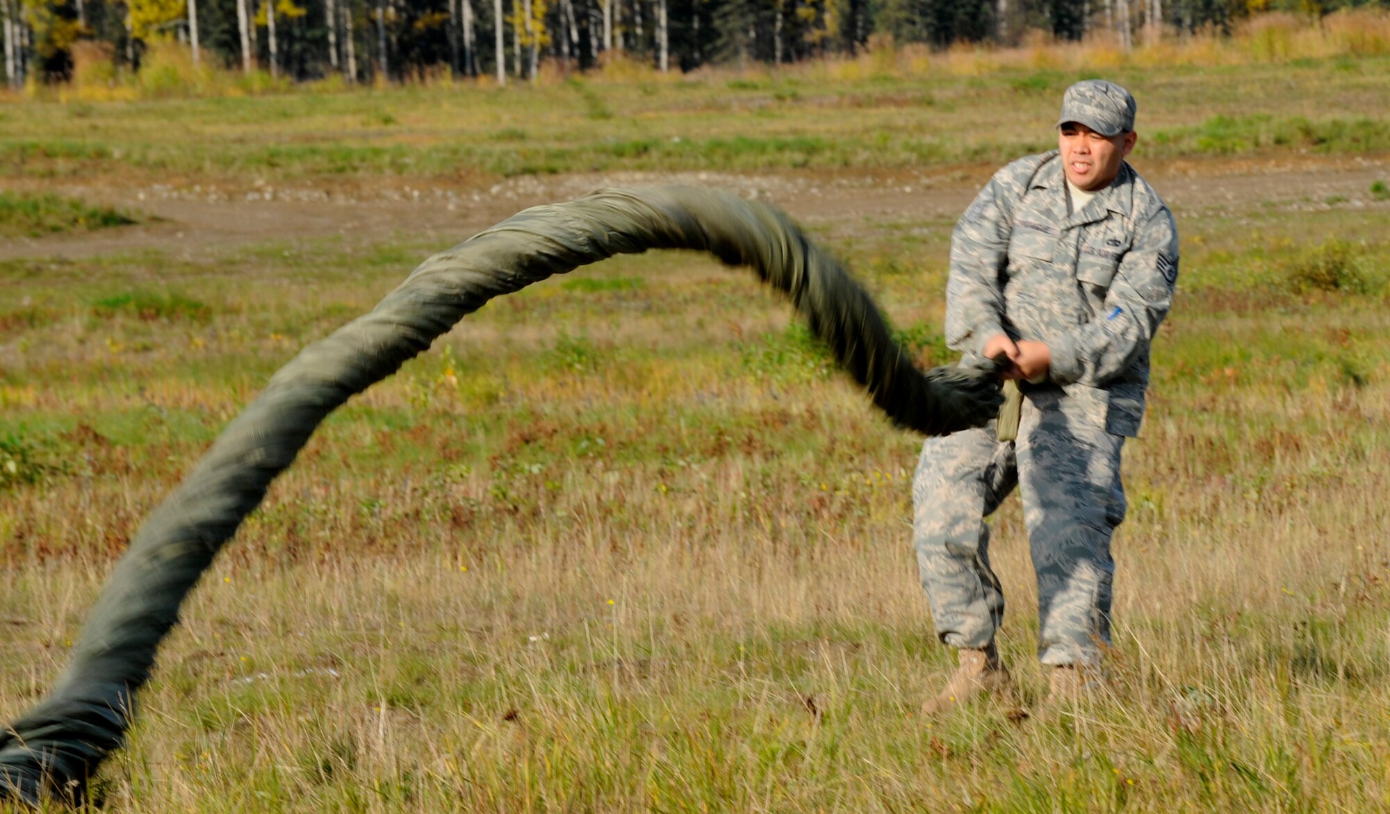ELMENDORF AIR FORCE BASE, Alaska -- Staff Sgt. Aaron Pocaigue, 3rd Logistics Readiness Squadron, wraps a parachute from an aerial delivery Sept. 26. The 3rd LRS uses these drops to prepare for aerial deliveries in wartime situations. (U.S. Air Force photo/Airman 1st Class Kristin High)