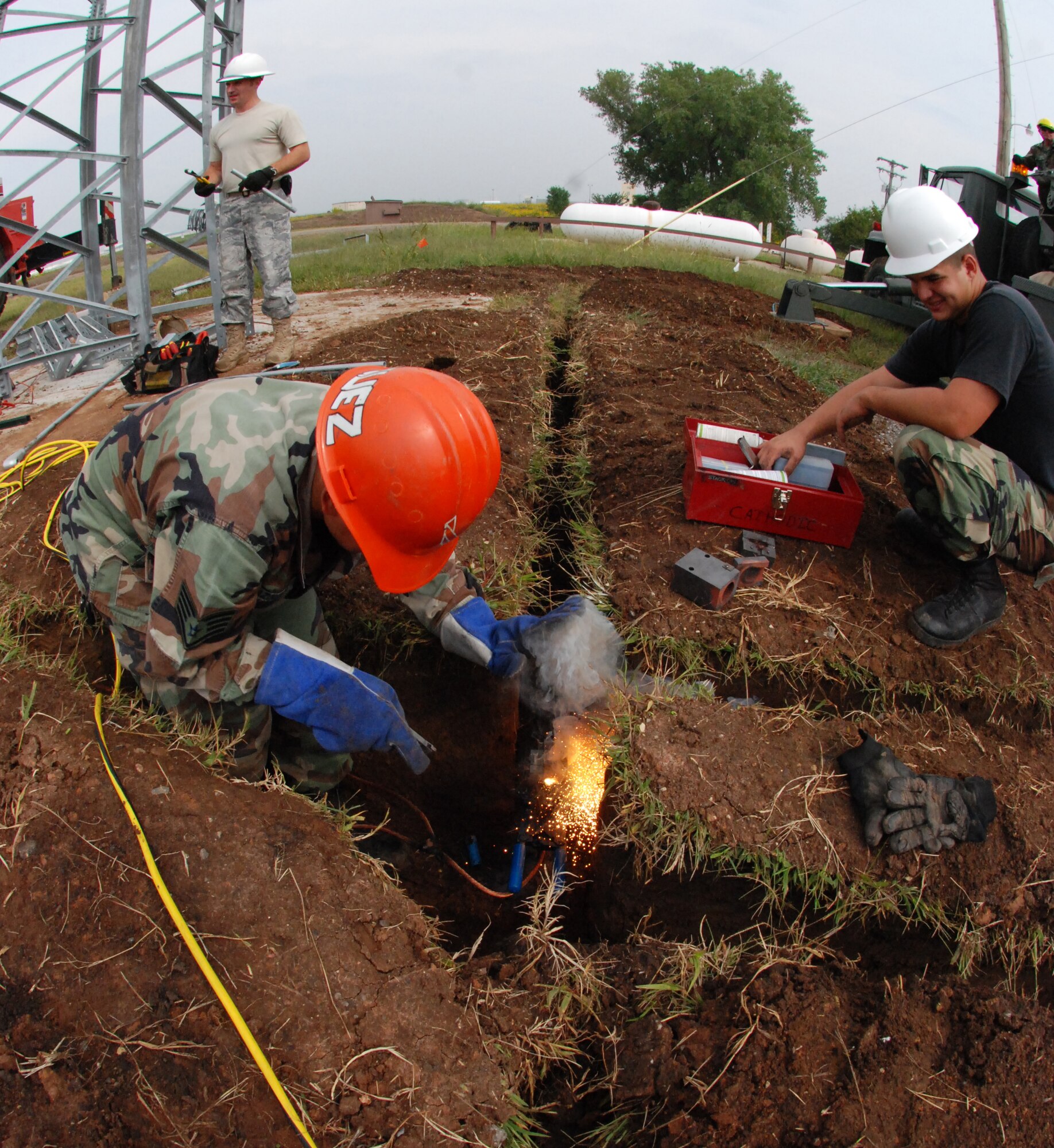 Airman Bradley Vanzandt (on right) helps Staff Sgt. Martin Vazquez, 22nd Civil Engineer Squadron, use an exothermic welding tool around one of two new Ground-to-Air Transmitter/Receiver towers at McConnell Air Force Base, Kan. Airman Vanzandt is a traditional Reservist assigned to the 931st Civil Engineer Squadron currently training with engineers of the 22nd Air Refueling Wing, the 931st's host unit at McConnell. (U.S. Air Force photo/Airman 1st Class Jessica Lockoski)