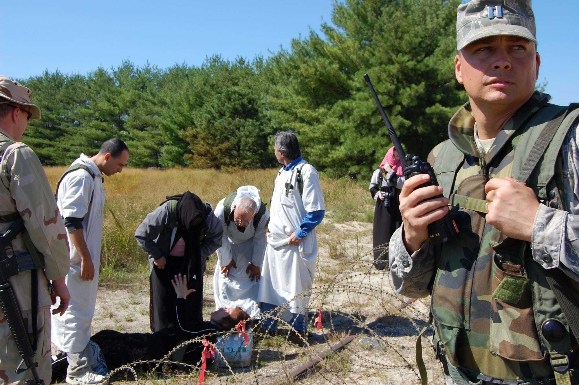Capt, Mark Miller, deployed public affairs officer for Air Force Exercise Eagle Flag 08-6, work with other Airmen to control protesters in the fictional country of Chimaera during a scenario for Eagle Flag Sept. 21, 2008, at Naval Air Engineering Station Lakehurst, N.J.  The exercise is managed by the U.S. Air Force Expeditionary Center's 421st Combat Training Squadron and tests and trains Airmen in expeditionary combat support skills.  (U.S. Air Force Photo/Staff Sgt. Desiree N. Palacios)
