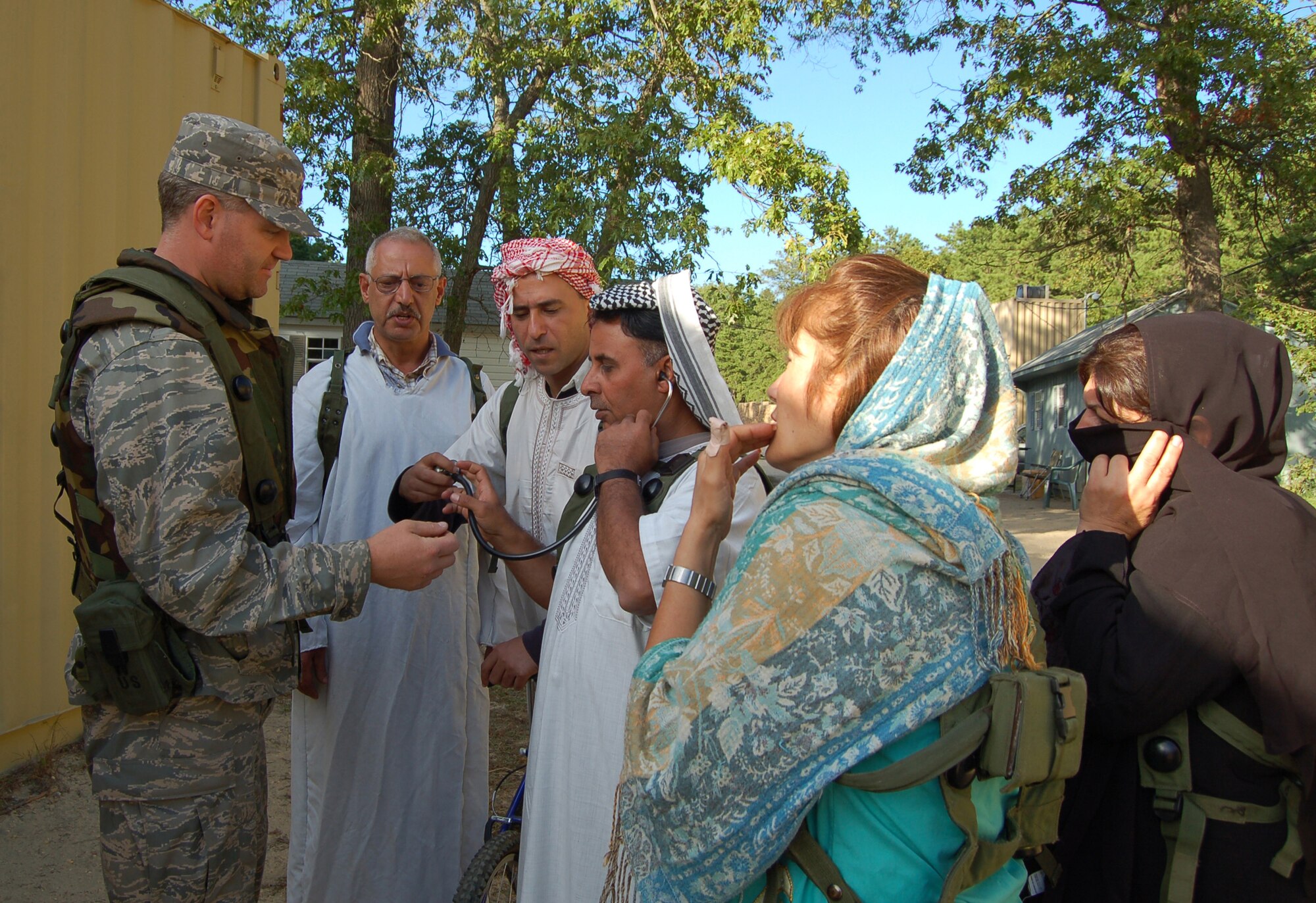 Capt. Daniel O?Connor, an Air Force flight surgeon participating in Air Force Exercise Eagle Flag 08-6, shows medical equipment to the "villagers" in the fictional village of Citheron during a scenario for Eagle Flag Sept. 20, 2008, at Naval Air Engineering Station Lakehurst, N.J.  The exercise is managed by the U.S. Air Force Expeditionary Center's 421st Combat Training Squadron and tests and trains Airmen in expeditionary combat support skills.  (U.S. Air Force Photo/Senior Airman Julius Delos Reyes)