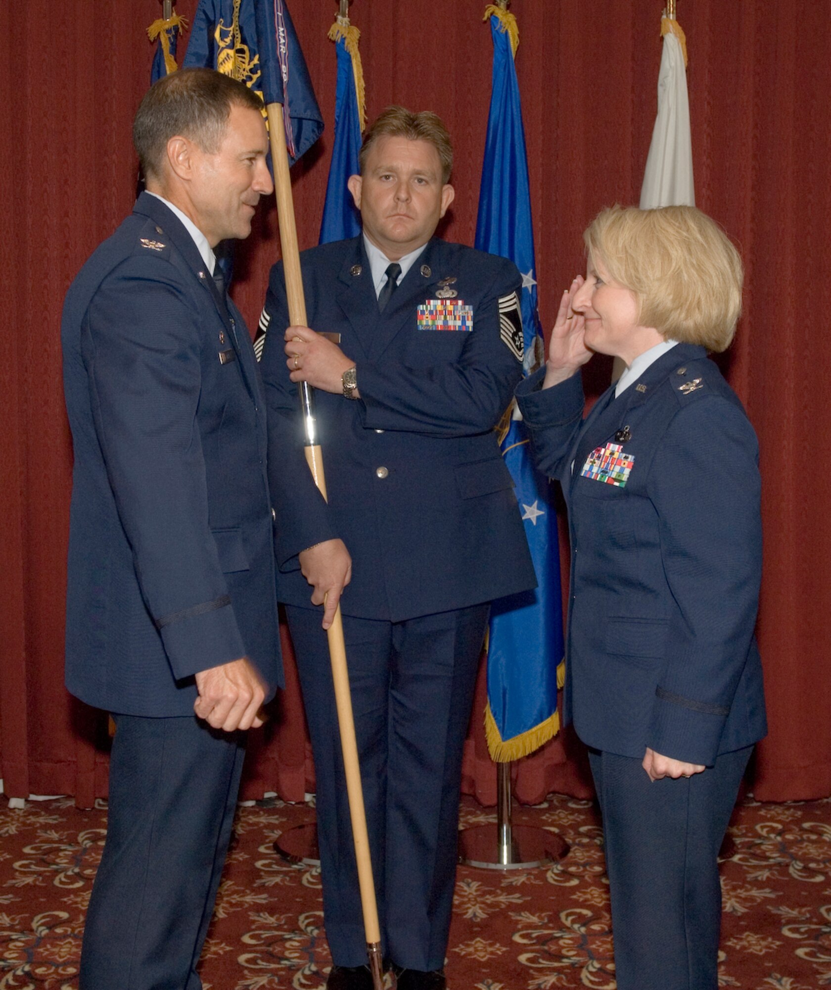 HANSCOM AFB, Mass. – Col. Deborah L. Van De Ven (right) renders a salute to Col. David Orr (left), 66th Air Base Wing commander, as she prepares to take command of the 66th Mission Support Group, while Chief Master Sgt. Michael McCoy holds the 66 MSG flag during the Change of Command ceremony on Sept. 29 at the Minuteman Club. (U.S. Air Force photo by Rick Berry)