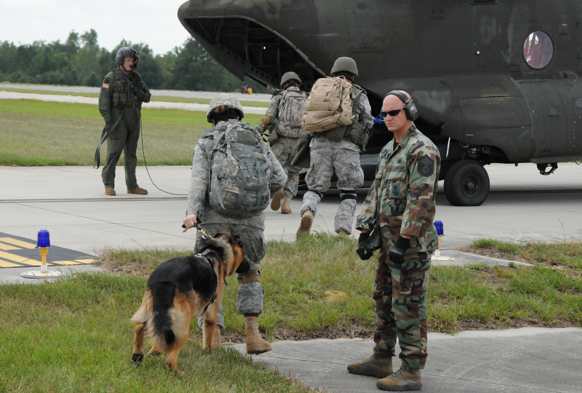 FORT RUCKER, Ala. -- Master Sgt. Todd Coning, right, observes several MWD handlers as they board a Chinook Sept. 12. The airmen completed a training mission here to acclimate their MWDs to helicopter flight and prepare for an upcoming deployment. (Photo by Michelle Owens)