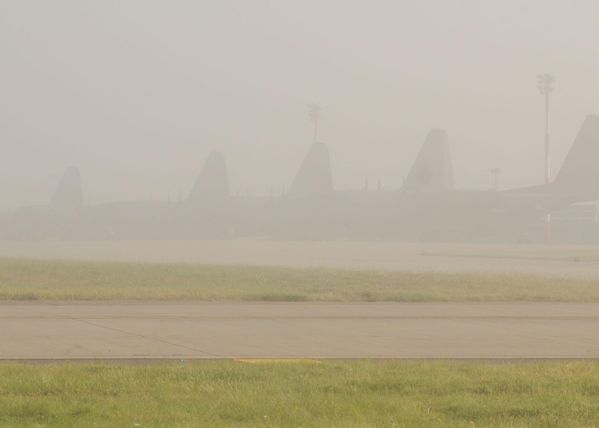 A row of C-130s from the 352nd Special Operations Group, sits hidden under heavy fog Sept 26, 2008, at RAF Mildenhall, England. According to  base safety officials, dense fog can make for zero visibility, motorists are warned to take more time and to be alert during morning commutes. (U.S. Air Force by Staff Sgt. Jerry Fleshman)