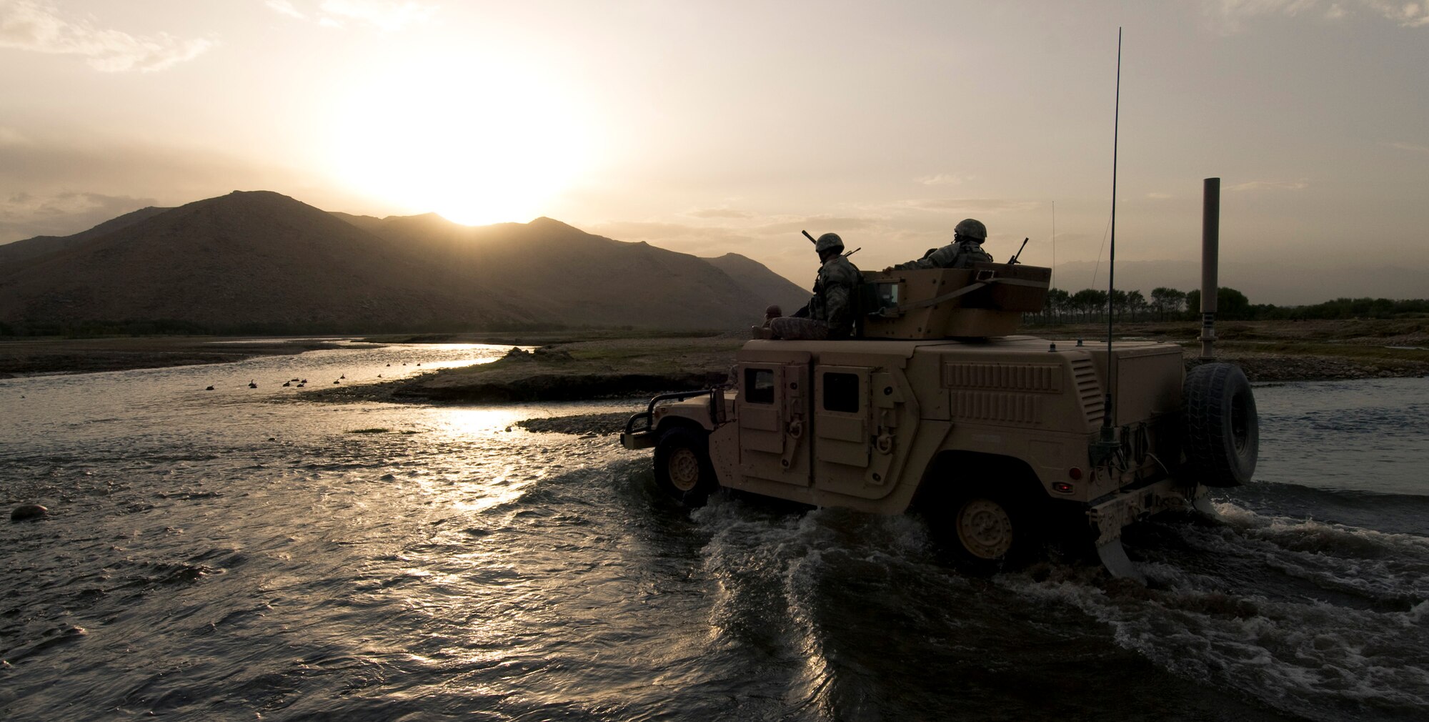 A Humvee crosses a river in Afghanistan last month. A few of the dismounted Airmen temporarily ride on top of the Humvee to keep their boots dry.  (U.S. Air Force photo/Staff Sgt. Samuel Morse) 
