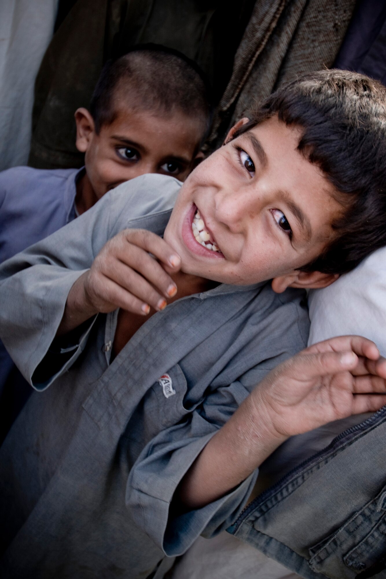 A boy looks up at the camera in an Afghan village. The children smiled at the sight of coalition forces despite the continuing food shortages and violence in Afghanistan. (U.S. Air Force photo/Staff Sgt. Samuel Morse) 
