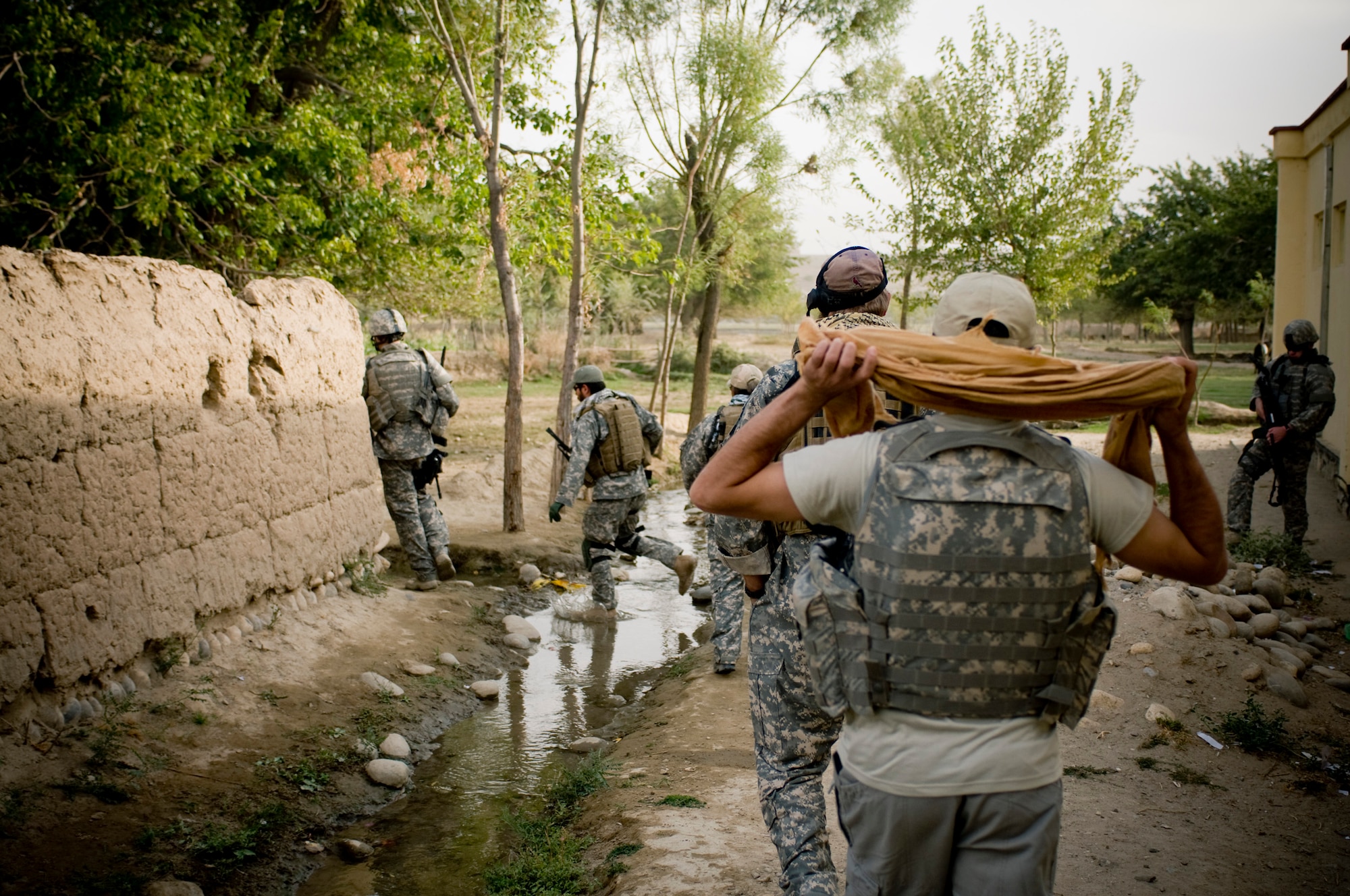 Airmen enter an Afghan village recently. The coalition force wanted to learn more about the village and offer help to ensure the village's security. (U.S. Air Force photo/Staff Sgt. Samuel Morse) 
