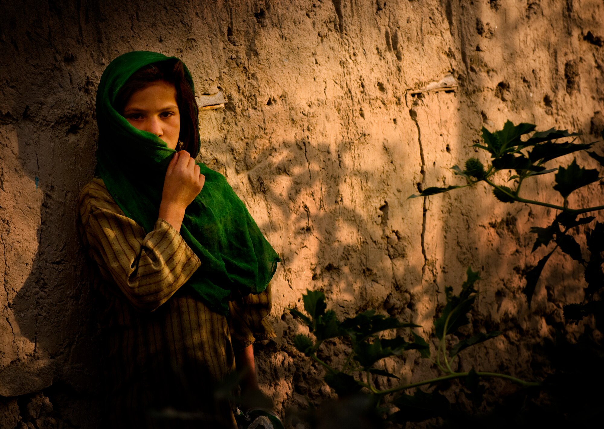 An Afghan girl covers her face from the dusty wind recently in a village in Afghanistan. Curiosity drew the child out, but she remained shy of the foreigners who entered her village. (U.S. Air Force photo/Staff Sgt. Samuel Morse) 
