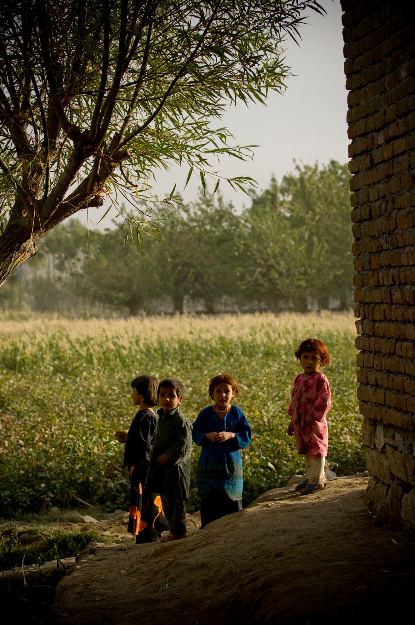 Small children stop to look at the commotion recently in an Afghan village. The presence of coalition forces drew most of the village out of their homes for curiosity's sake. (U.S. Air Force photo/Staff Sgt. Samuel Morse)