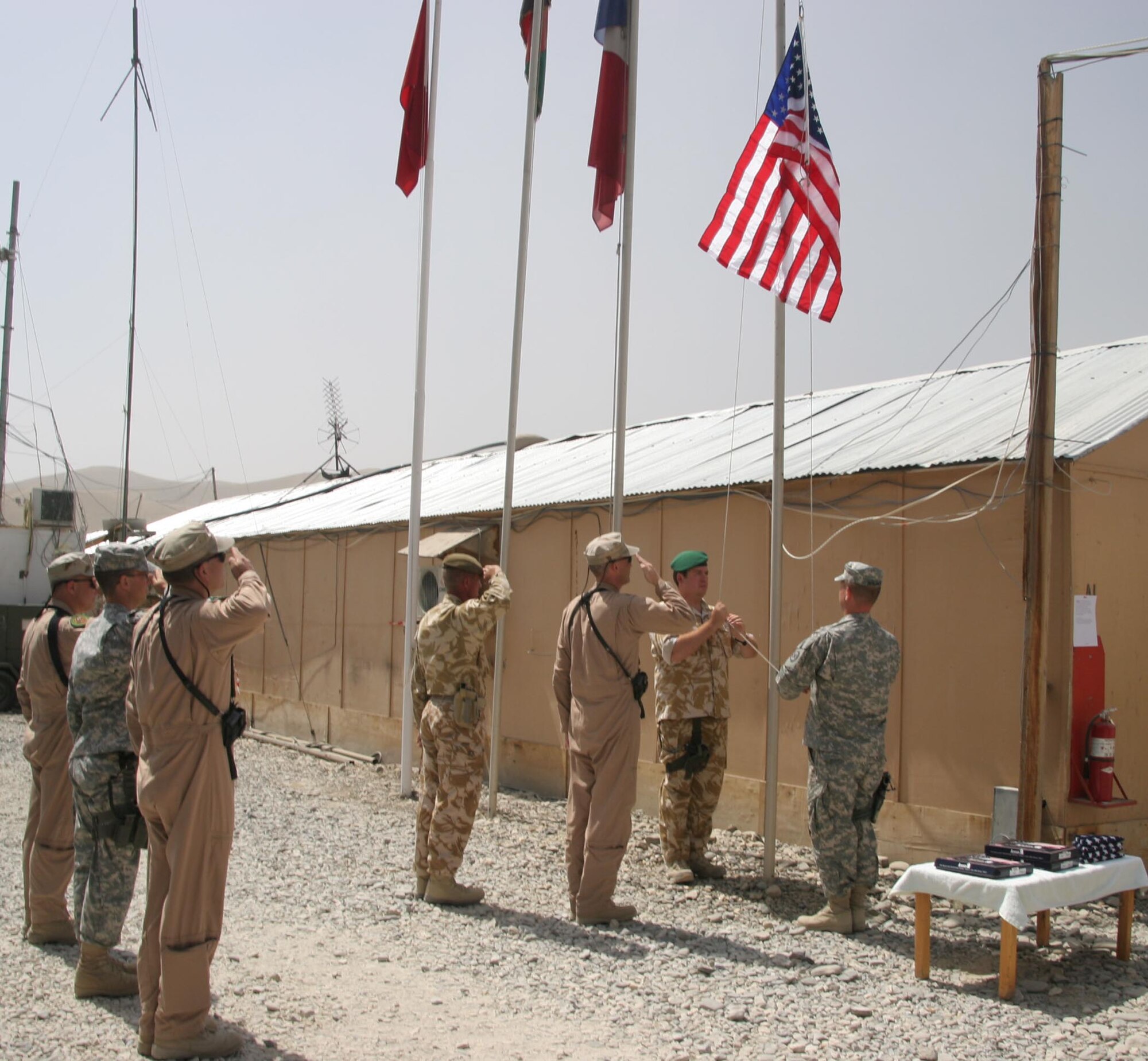 BAGRAM AIR FIELD, Afghanistan  -- Members of the Combined Training and Advisory Group pay tribute to 9-11 with a flag ceremony on Camp Dubs on Sept. 11. (Photo printed with permission of Capt. Brian Clough)