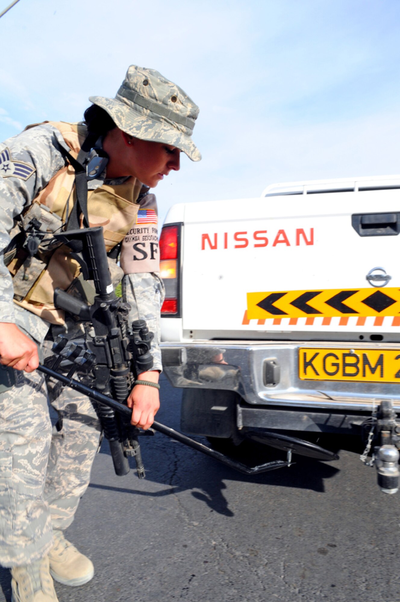 MANAS AIR BASE, KYRGYZ REPUBLIC -- Senior Airman Jillian Decair, 376th Expeditionary Security Forces Squadron, performs a random vehicle check here, Sept. 27. The 376th ESFS protects the base from any threats it may face from both inside and outside the perimeter. (Air Force photo / Senior Airman Ruth Holcomb)