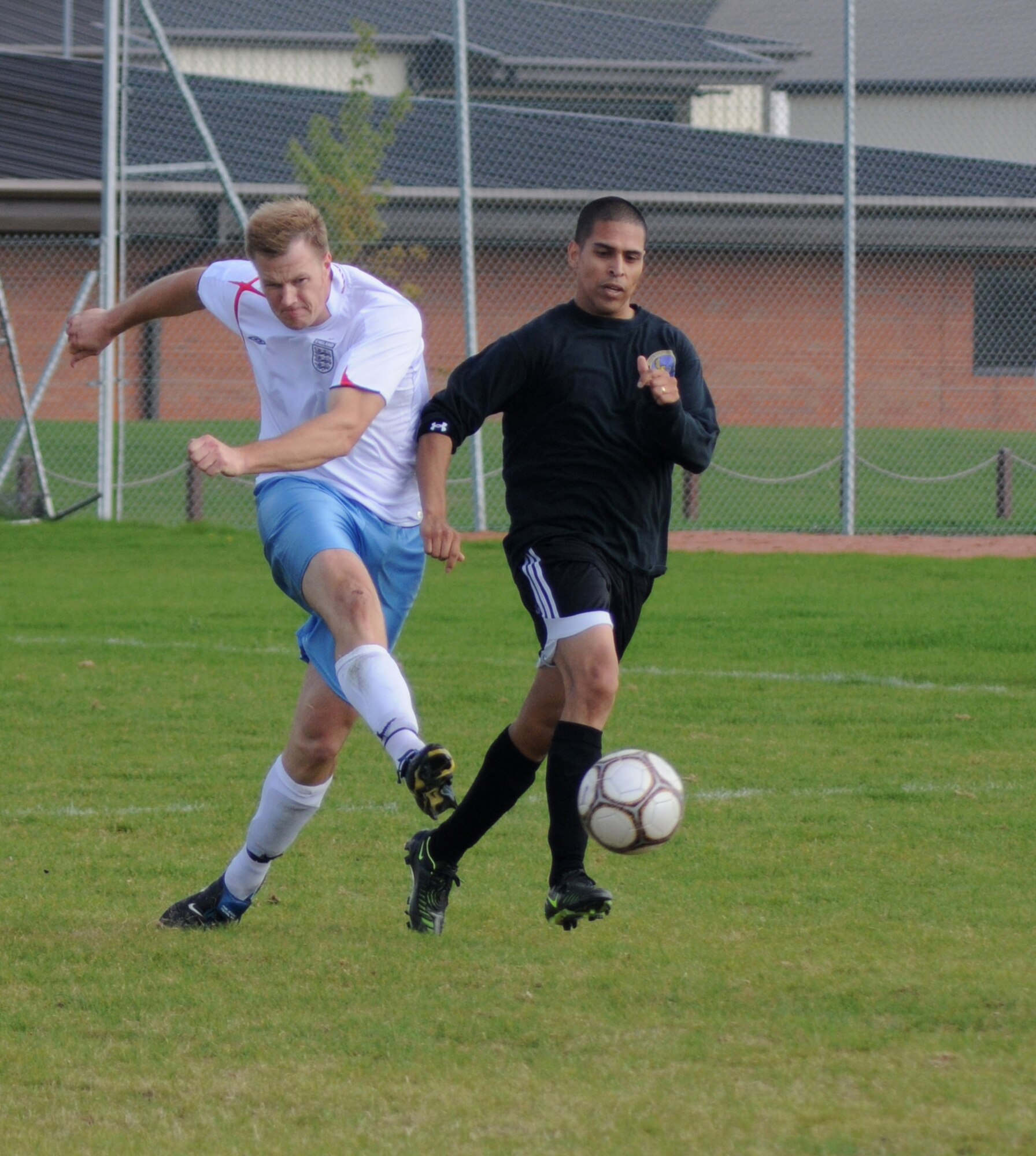 Steven Alverson, from the 95th RS, beats Carlos Rojas, (in black) to the ball and scores with a stunning shot to tie the game at 2-2 during the outdoor soccer championship at the Hardstand Sports field, Sept. 26. (U. S. Air Force photo by Staff Sgt. Jerry Fleshman)