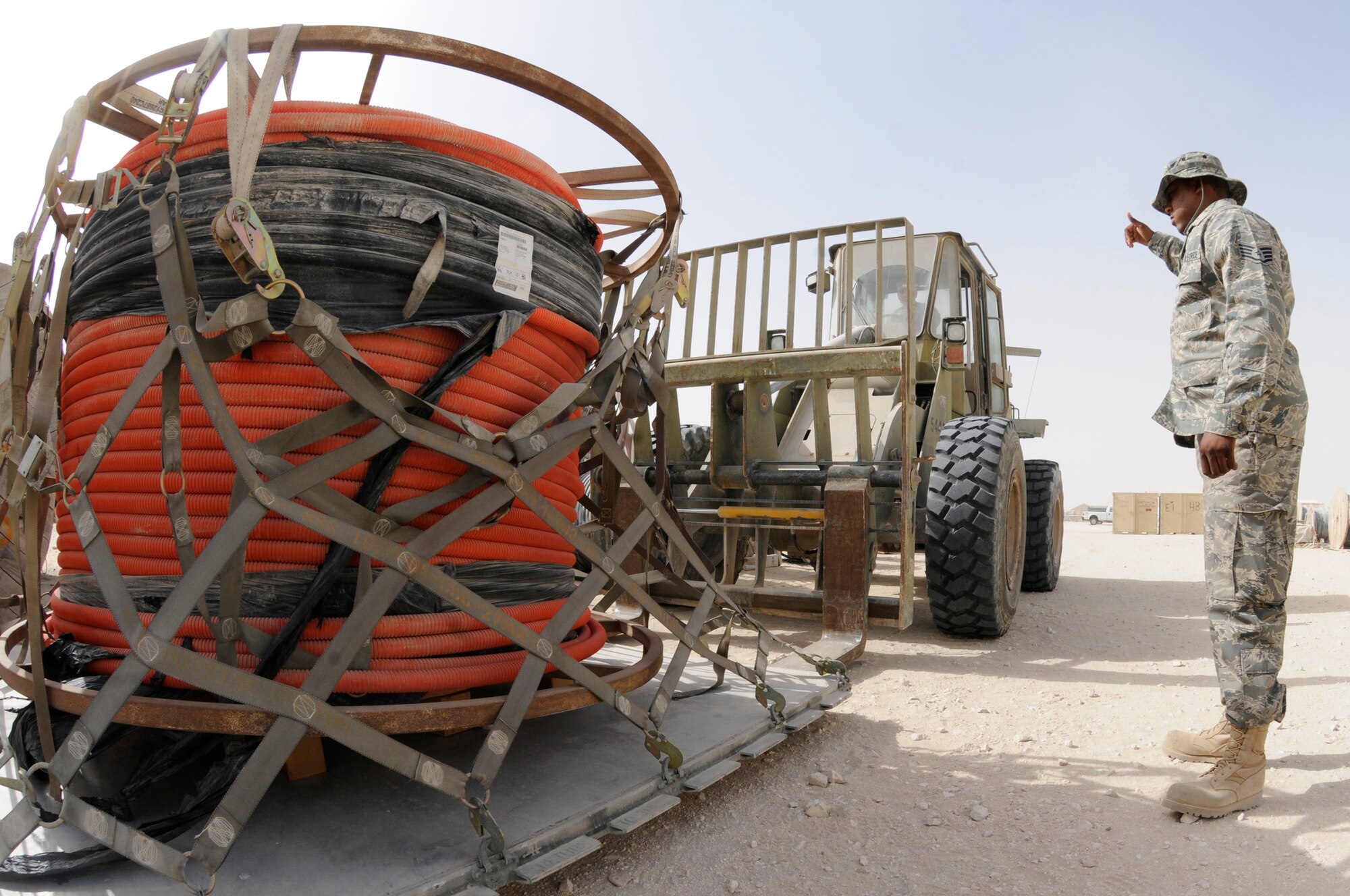 Staff Sgt. Obie Balton uses his hands to relay operating instructions to Staff Sgt. Justin Ross, operating the forklift, to move a pallet of inner duct Sept. 29, 2008, at an undisclosed air base in Southwest Asia. Both are engineering installation supply personnel responsible for storing and moving supplies that will be used in the global war on terrorism. Sergeant Balton, a native of Dallas, Texas, is deployed from the Oklahoma Air National Guard, Tulsa, Okla., and Sergeant Ross, a native of Columbus, Ohio, is deployed from the Ohio Air National Guard, Zanesville, Ohio.  Both are assigned to the Combined Air and Space Operations Center supporting Operations Iraqi and Enduring Freedom and Joint Task Force-Horn of Africa. (U.S. Air Force photo by Staff Sgt. Darnell T. Cannady/Released)