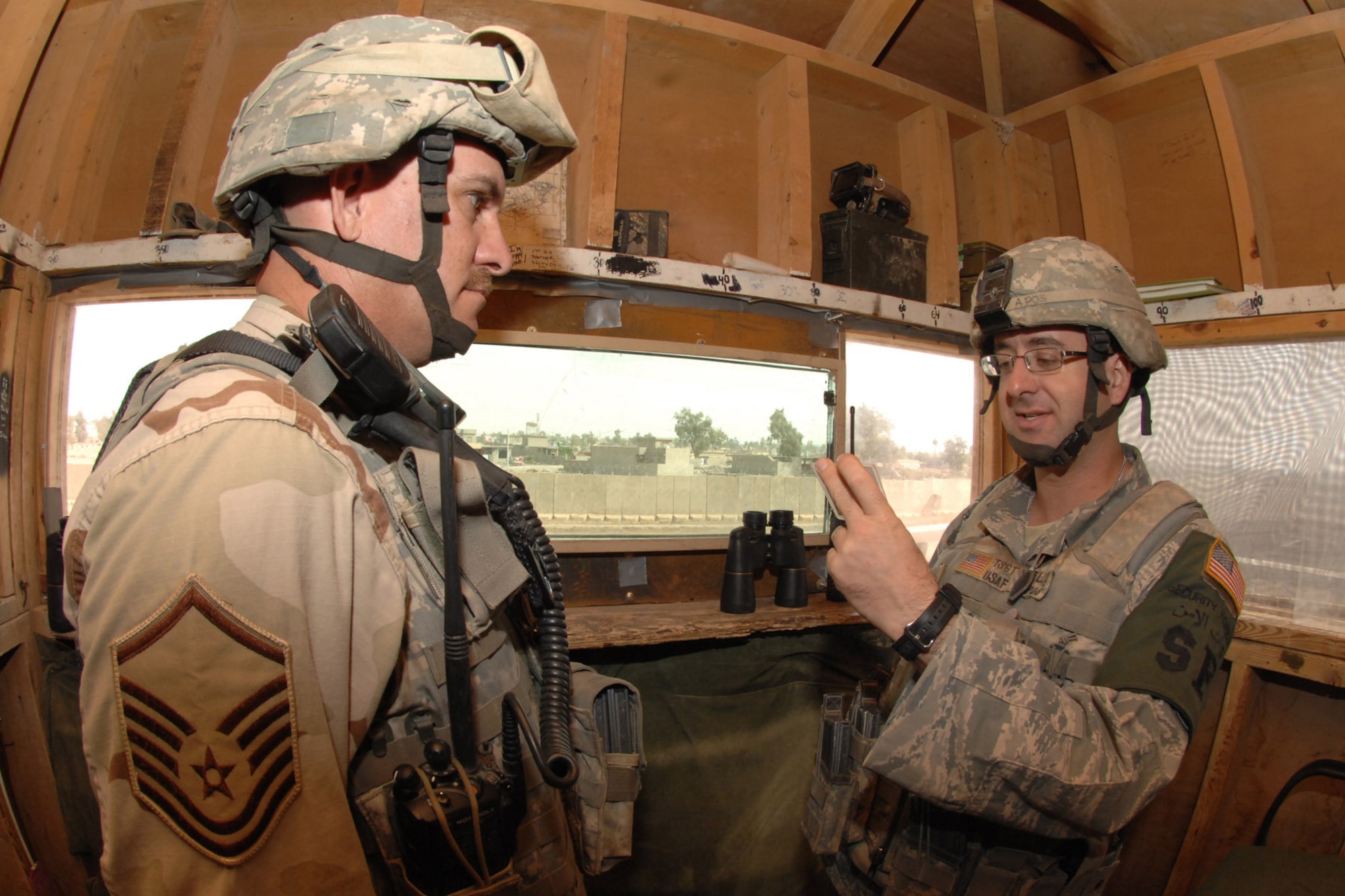KIRKUK REGIONAL AIR BASE, Iraq -- Tech. Sgt. Michael Yavello, 506th Expeditionary Security Forces Squadron response force leader, reads a post brief to Master Sgt. John Newman, 506th ESFS assistant flight chief, here Sept 27.  Sergeants Newman and Yavello are one of many security forces Airmen deployed to ensure base defense.  The 506th ESFS, the largest squadron on Kirkuk, comprises almost half of the 506th Air Expeditionary Group and includes both active-duty and reserve Airmen from 32 different home-station units.  Both sergeants are deployed from Luke Air Force Base, Ariz.  Sergeant Newman calls Abondale, Ariz., home and Sergeant Yavello calls Scottsdale, Ariz., home.(U.S. Air Force photo/Senior Airman Randi Flaugh) 