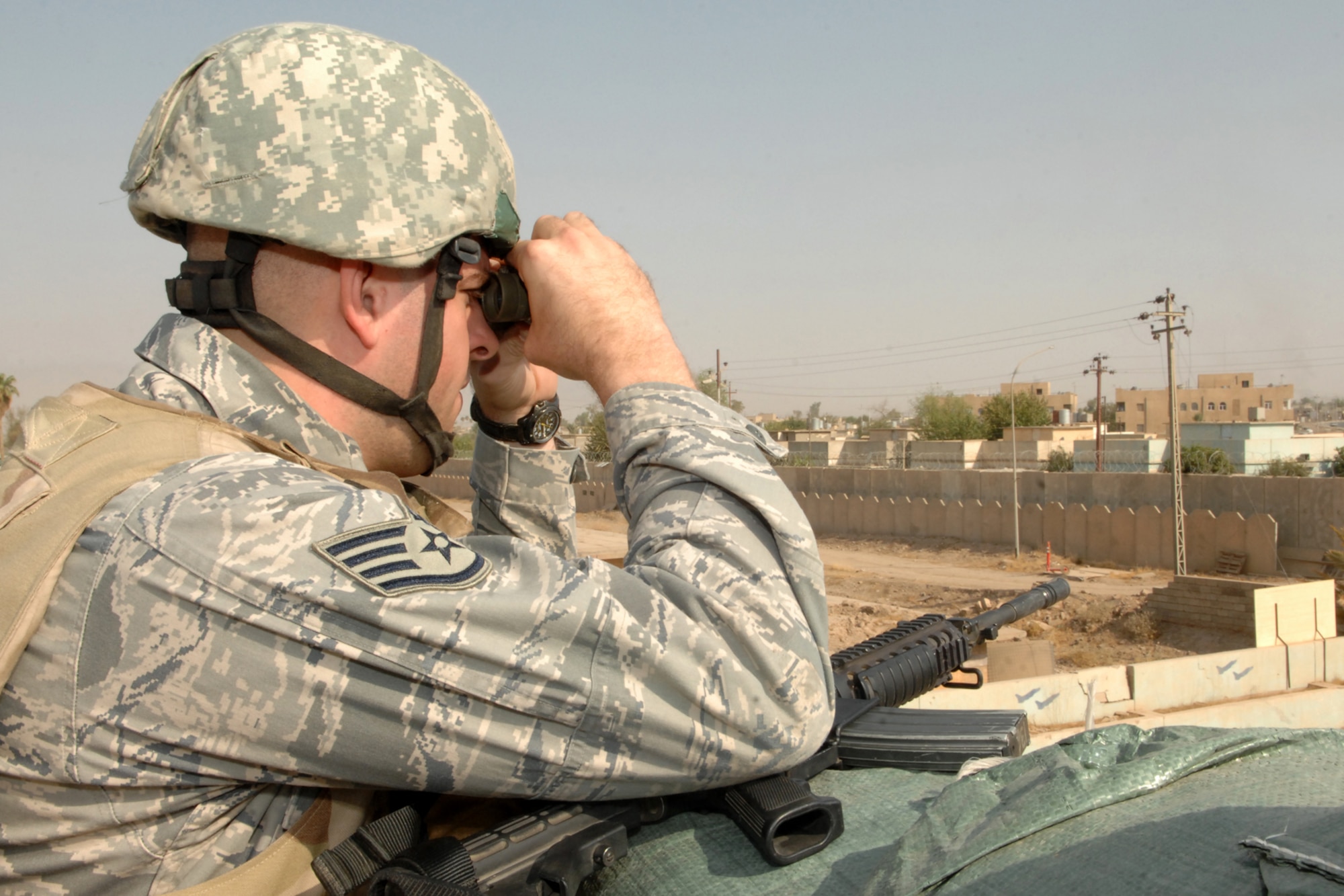 KIRKUK REGIONAL AIR BASE, Iraq -- Staff Sgt. Steven Baugher, 506th Expeditionary Security Forces Squadron mobile patrol and listening post and observation post leader, keeps a watchful eye over the city of Kirkuk here Sept 2. Sergeant Baugher is one of many security forces Airmen deployed to ensure base defense.  The 506th ESFS, the largest squadron on Kirkuk, comprises almost half of the 506th Air Expeditionary Group and includes both active-duty and reserve Airmen from 32 different home-station units.  Sergeant Baugher is deployed from Naval Air Station Fort Worth Joint Reserve Base Carswell Field, Texas and calls Abilene, Texas home.  (U.S. Air Force photo/Senior Airman Randi Flaugh)