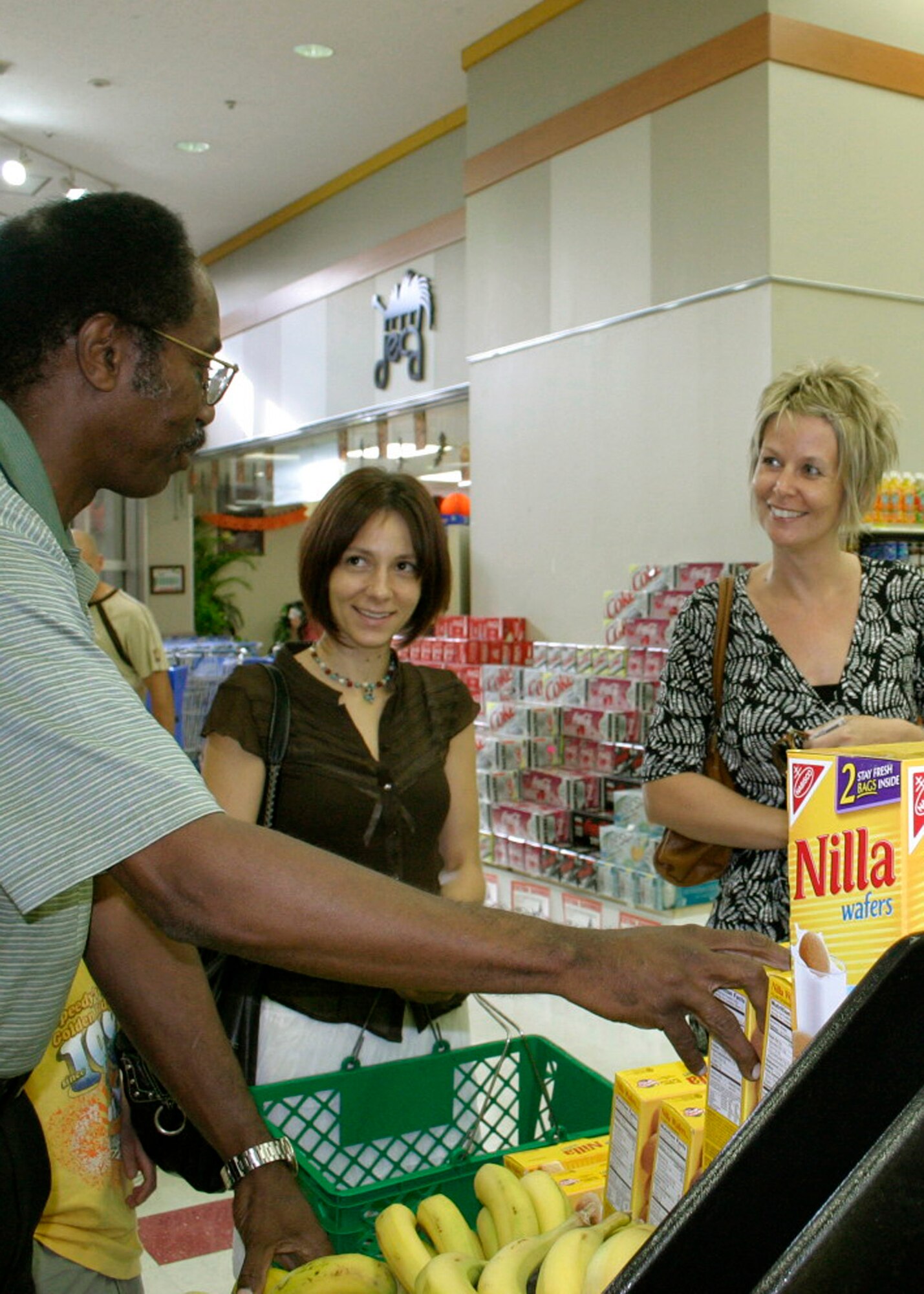 MISAWA AIR BASE, Japan -- Greg McGruder, commissary manager, speaks with customers Katie Cudzilo and Britta Strop about the produce displayed Sept. 4, 2008. Inputs from customers help Mr. McGruder and his team provide quality produce at lower prices. (U.S. Air Force photo by Staff Sgt. Araceli Alarcon)