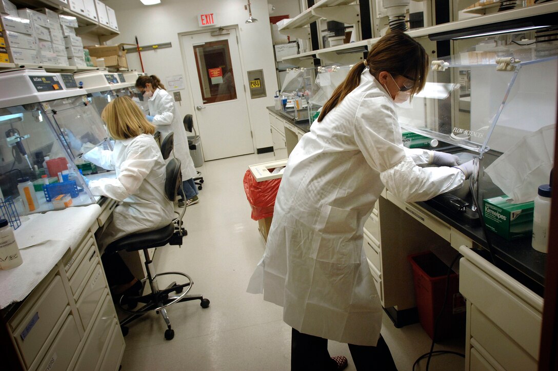 Mitochondrial DNA analysts Christina Miller, right, Jamie Steinitz, center, and Jennifer Kappeller work to prepare bone and tooth samples for DNA extraction. The DNA lab is one of the oldest and largest labs in the world that works with ancient DNA testing, or testing from severely degraded samples. DoD photo by Fred W. Baker III