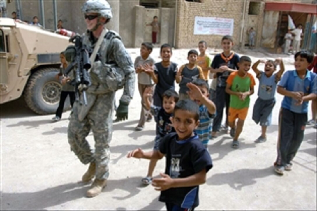 U.S. Army Spc. Steve Stewart leads an entourage of festive children down a road as his unit conducts Operation Boar Bobcats, a cordon and search mission in Muhallah 762 in Oubaidy, eastern Baghdad, Iraq, Sept. 28, 2008. The soldiers are assigned to Alpha Company, 2nd Battalion, 30th Infantry Regiment, 4th Brigade Combat Team, 10th Mountain Division.