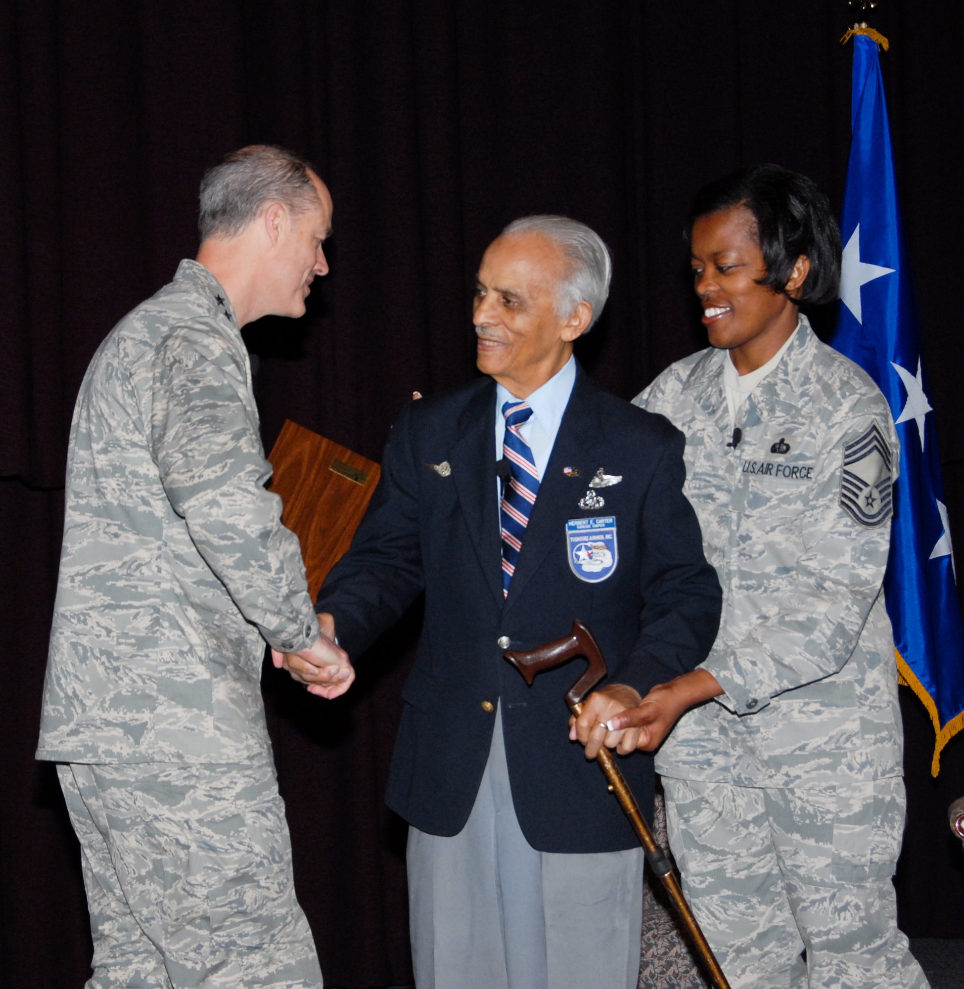 While speaking at Gunter's Senior Non-Commissioned Officer Academy on April 1, Lt. Col. (ret.) Herbert Carter was surprised with the academy's honorary diploma by Lt. Gen. Allen G. Peck (left), commander of Air University. Colonel Carter was invited to the academy to tell of his experiences as a member of the famed Tuskegee Airmen of World War II. According to the academy's Chief Master Sgt. Michael Foster, Colonel Carter has spoken to 68 SNCOA classes and more than 20,000 students since 1997. Also shown is Chief Master Sgt. Shelia Knox, vice commandant of the SNCOA. (Air Force photo by Bud Hancock)