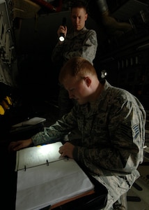 Tech. Sgt. Robert Pellam and Staff Sgt. Andrew Alford review aircraft forms to ensure all discrepancies are documented so maintenance can correct the deviations here April 1. Quality assurance checks are performed to ensure maintenance quality, personal safety, reliability and flight safety are adhered to for the 437th Maintenance Group. Sergeant Pellam is a crew chief quality assurance inspector and Sergeant Alford is a fabrication quality inspector. Both are with the 437th Maintenance Group. (U.S. Air Force photo/Senior Airman Timothy Taylor)