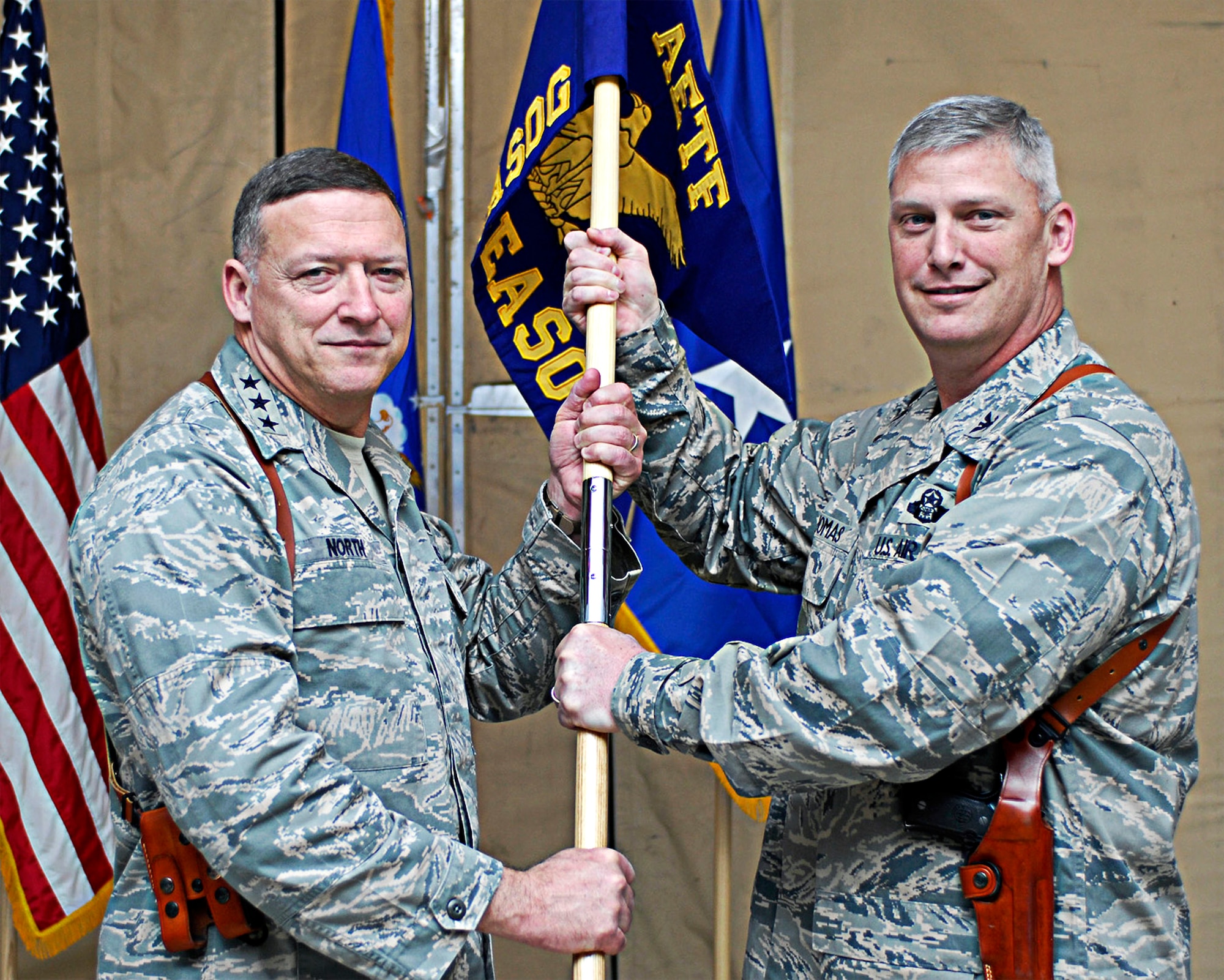 Lt. Gen. Gary North (left), commander of 9th Air Force and U.S. Air Forces Central, hands the 504th Expeditionary Air Support Operations Group guidon to Col. James Thomas March 30 who assumes command of the newly activated unit at Bagram Air Field, Afghanistan. The colonel is the first commander of the group comprising more than 125 air liaison officers and tactical air control party and combat weather Airmen deployed throughout Afghanistan.  (U.S. Air Force photo/Senior Airman Erik Cardenas)