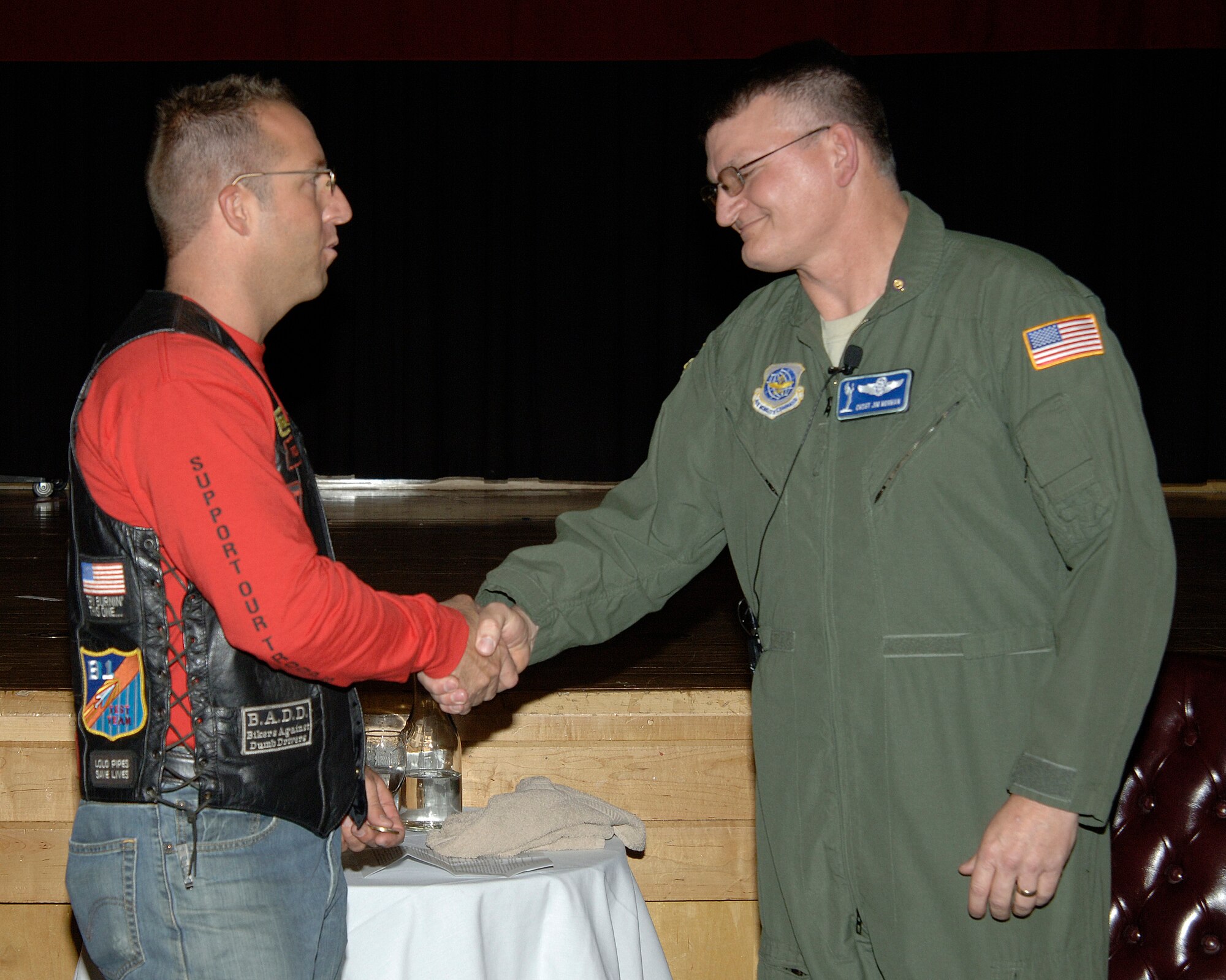 MCCONNELL AIR FORCE BASE, Kan. -- The American Legion Riders, represented by Wayne Tibbs, present Chief Master Sgt. James Morman, 22nd Air Refueling Wing former interim command chief, with a few tokens during his retirement ceremony at the Robert J. Dole Community Center ballroom, March 27. The American Legion Riders brought an autographed banner and coin for Chief Morman. (Photo by Senior Airman Laura Suttles)
