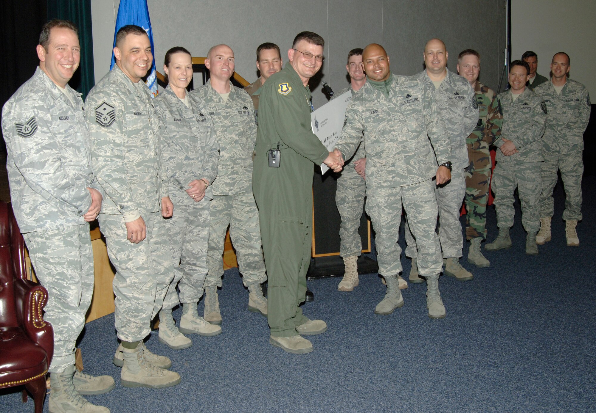 MCCONNELL AIR FORCE BASE, Kan. -- Master Sgt. Derick Clark, 22nd Maintenance Squadron, along with other first sergeants, presents Chief Master Sgt. James Morman, 22nd Air Refueling Wing former interim command chief with a retirement gift during his retirement ceremony. The first sergeants donated $100 for the Air Force Enlisted Village in Chief Morman’s name.  (Photo by Senior Airman Laura Suttles)