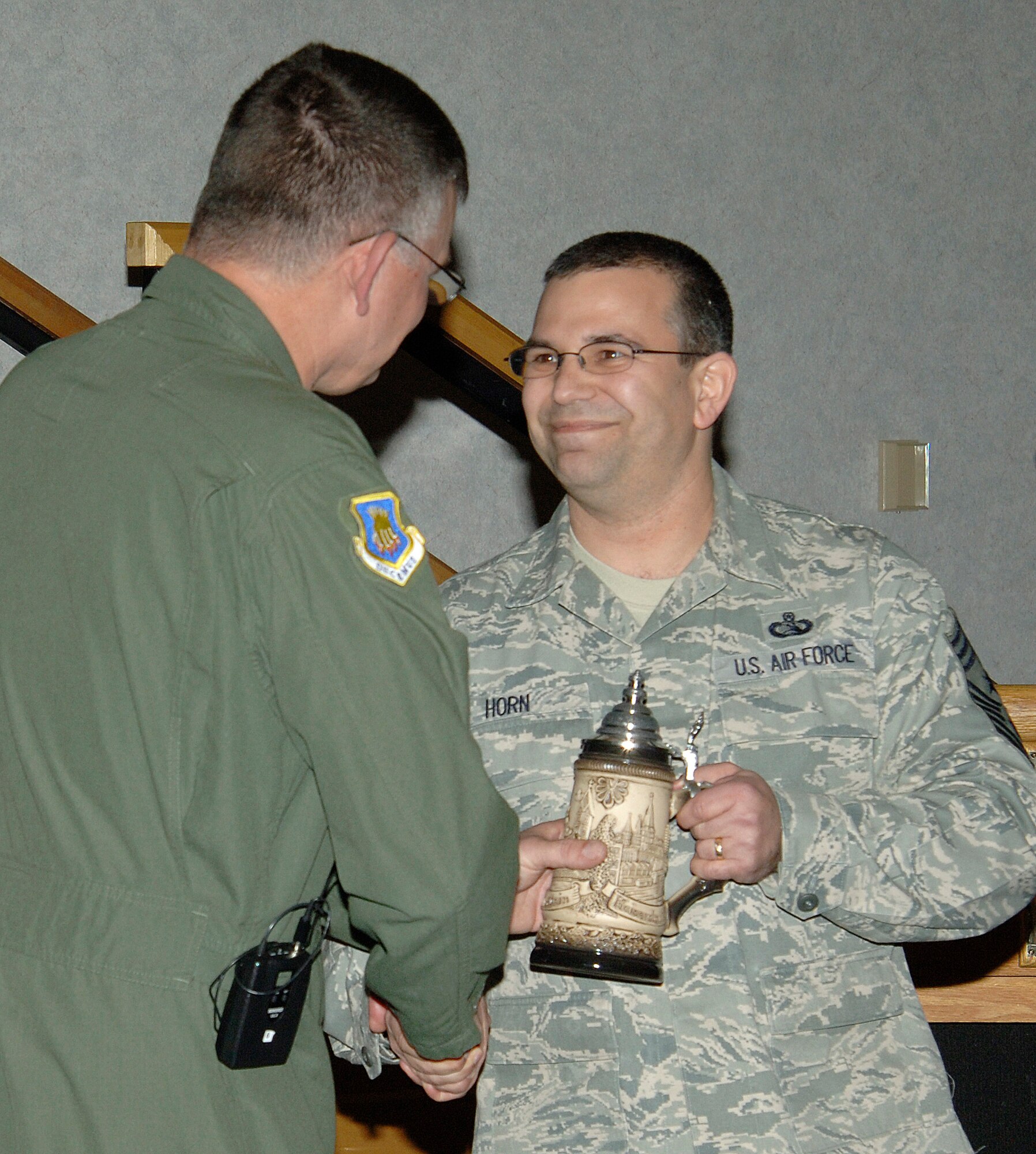 MCCONNELL AIR FORCE BASE, Kan. -- Chief Master Sgt. James Morman, 22nd Air Refueling Wing former interim command chief receives a congratulatory gift from the Chief Master Sgt. Timothy Horn, 22nd Air Refueling Wing command chief, during his retirement ceremony in the Robert J. Dole Community Center, March 27. Chief Morman held the position of interim command chief for the wing multiples times, the last of which he extended his time in the Air Force to fulfill the role. (Photo by Senior Airman Laura Suttles)