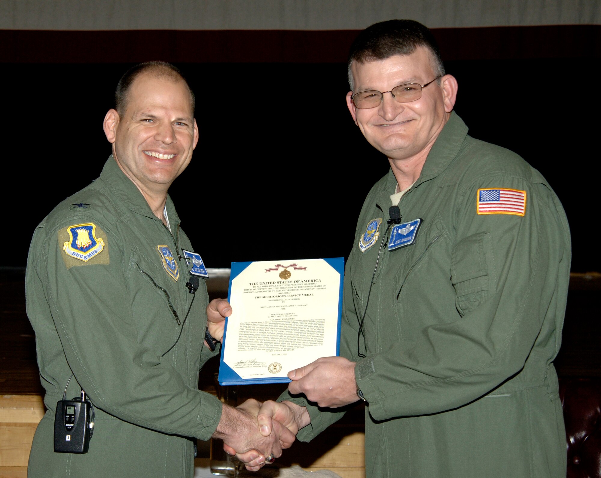 MCCONNELL AIR FORCE BASE, Kan. -- Col. James C. Vechery, 22nd Air Refueling Wing commander, provides Chief Master Sgt. James Morman, 22nd Air Refueling Wing former interim command chief, with a certificate for his Meritorious Achievement Medal during his retirement ceremony at the Robert J. Dole Community Center ballroom, March 27. Colonel Vechery acted as the presiding official during the ceremony, recalling to the audience different successes in Chief Morman’s career. (Photo by Senior Airman Laura Suttles)