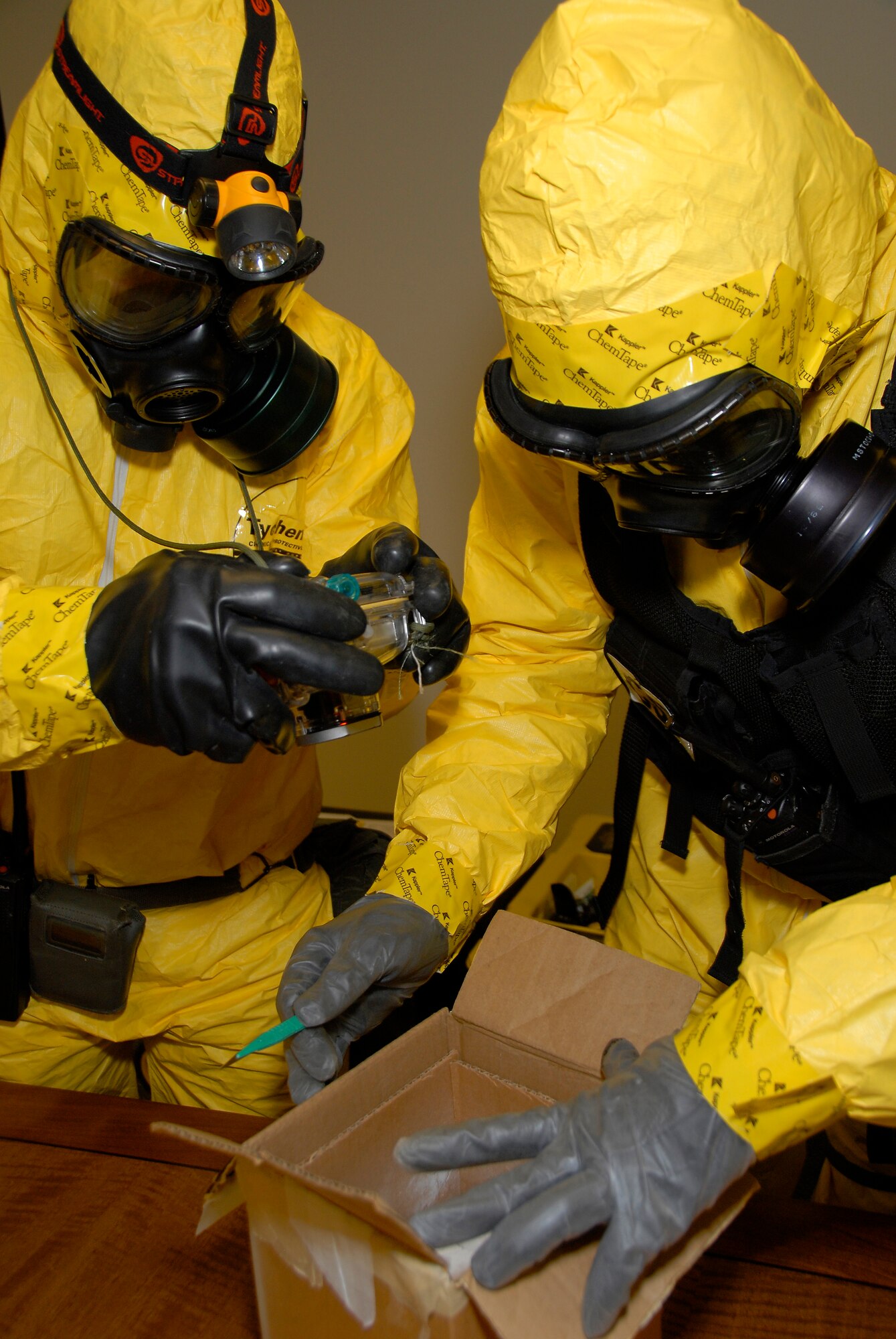 Two members of the 54th Civil Support Team open and examine the contents of a suspicious package during a joint exercise here March 18. The 54th CST provided support on examination, testing and extraction of the package. They also assisted the 115th Explosive Ordnance Disposal Flight with decontamination of their equipment. The joint exercise included many different units on Truax Field as well as the U.S. Postal Service, Federal Bureau of Investigation and the 54th CST. (U.S. Air Force Photo by Master Sgt. Dan Richardson)
