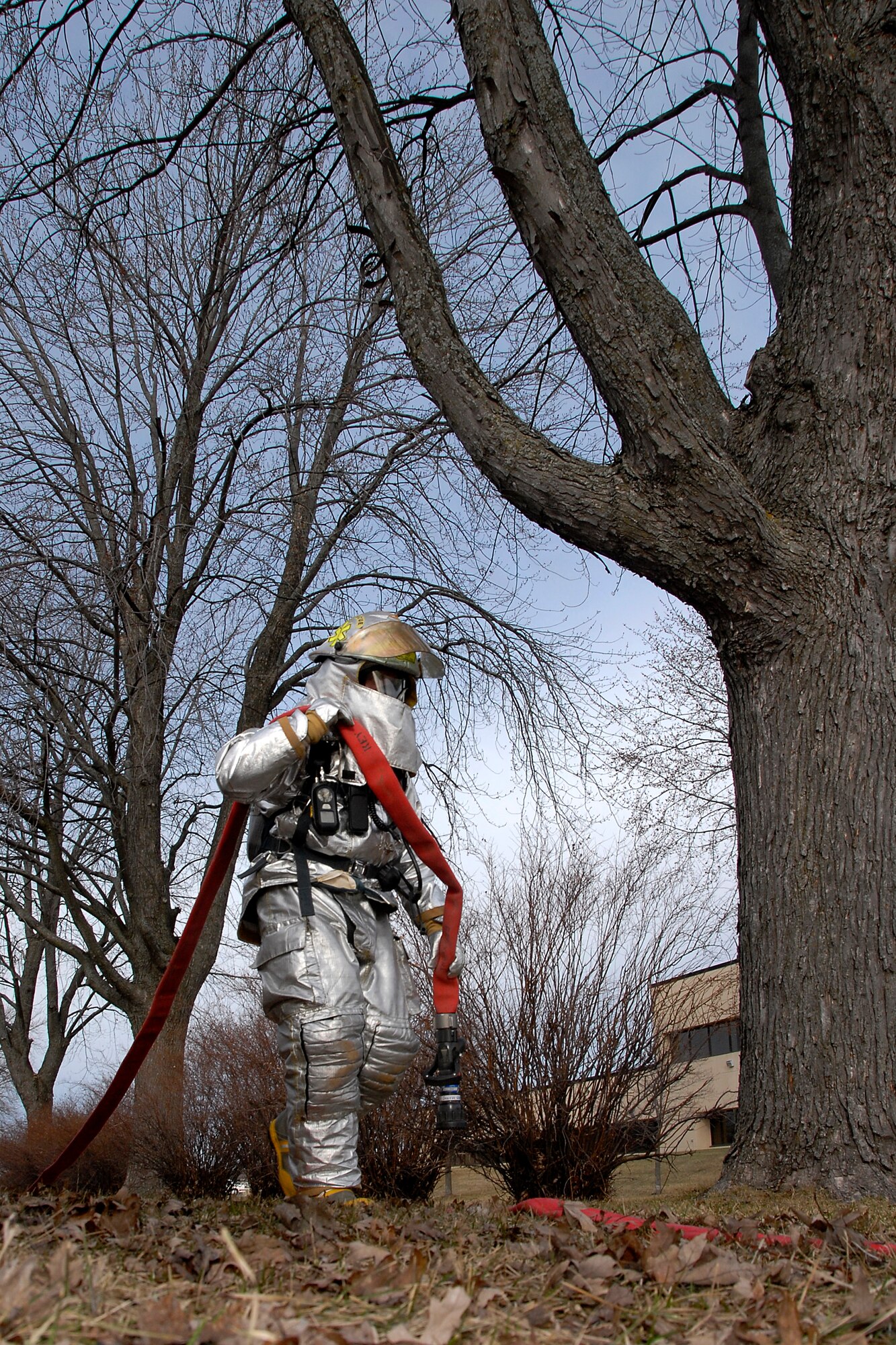 A fire fighter from the 115th Fighter Wing Fire Department walks a fire hose to the decontamination pool to prepare for any possible chemical contamination from a “suspicious” package that was found in Bldg. 500 March 18 as part of an exercise here. The joint exercise included many different units on Truax Field as well as the U.S. Postal Service, Federal Bureau of Investigation and the 54th Civil Support Team. (U.S. Air Force Photo by Master Sgt. Dan Richardson)