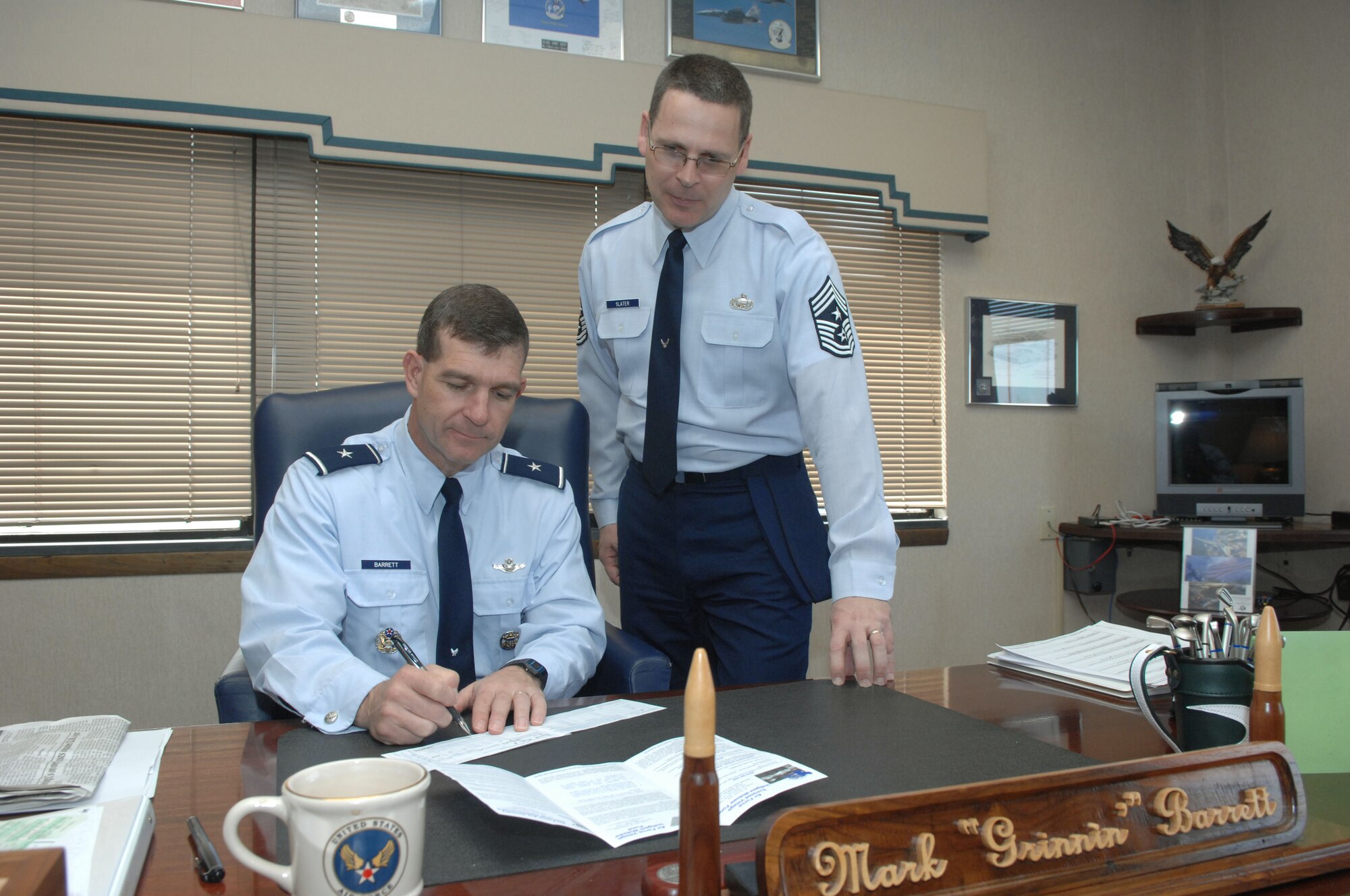 LANGLEY AIR FORCE BASE, Va. – Brig. Gen. Mark A. Barrett, 1st Fighter Wing commander, and Chief Master Sgt. Kevin Slater, 1st FW command chief, contribute to the Air Force Assistance Fund here March 30. The AFAF campaign has benefited active duty, Reserve, Guard, retired Air Force personnel, surviving spouses and families with contributions for 36 years. This year's campaign runs now till April 19, with a goal of raising $5.8 million. (U.S. Air Force Photo/Senior Airman Cecil C. McCloud)