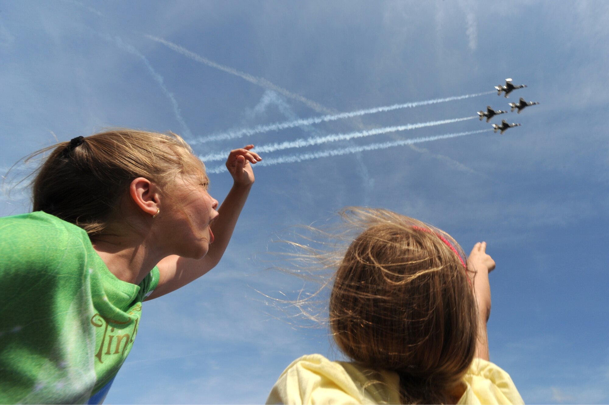 Alexandra Tiek (left), age 8, and Samantha Schnitt (right), age 7, of Tampa, Fla., cheer on the U.S. Air Force Thunderbirds as they soar overhead at the 2009 MacDill Airfest, Mar. 28.  The Thunderbirds will be performing in over 70 shows this year, to include stops in Puerto Rico and the Far East.  USAF Photo by Staff Sgt. Kristi Machado (RELEASED)