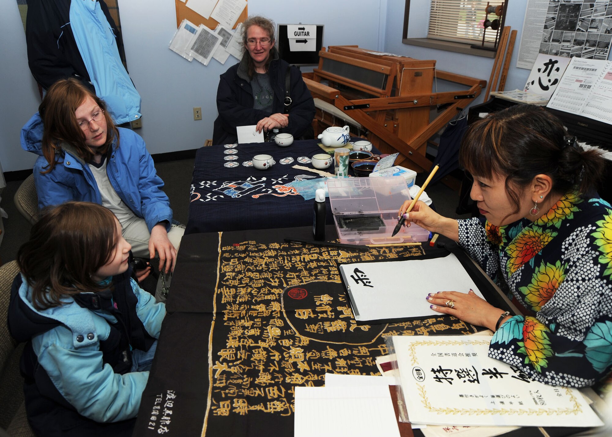 SCOTT AIR FORCE BASE, Ill. --Lauren and Amber Ruch, eagerly watch Yuki Tamayo, demonstrate the proper technique of writing Japanese calligraphy Saturday. (U.S. Air Force photo/Tech. Sgt. Michelle Larche) 