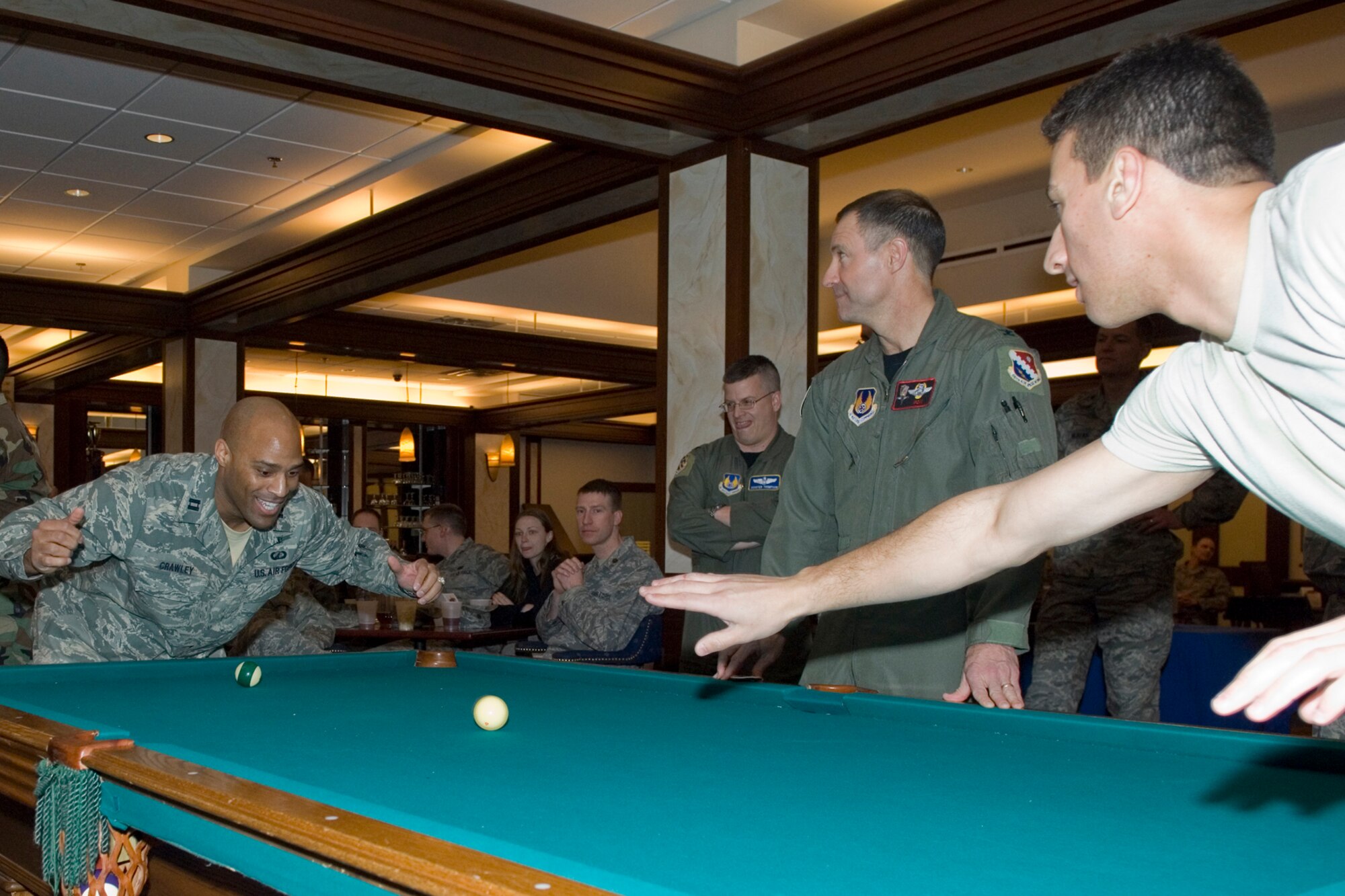 HANSCOM AIR FORCE BASE, Mass. – Capt. Wesley Crawley (left), 652nd Electronic Systems Squadron squares off against Second Lieutenant Frank Shiavone (right), 66th Contracting Squadron in a CRUD Tournament at the Minuteman Club, March 25, while Col. Dave Orr (center), 66th Air Base Wing commander judges the competition.  (U.S. Air Force photo by Mark Wyatt)