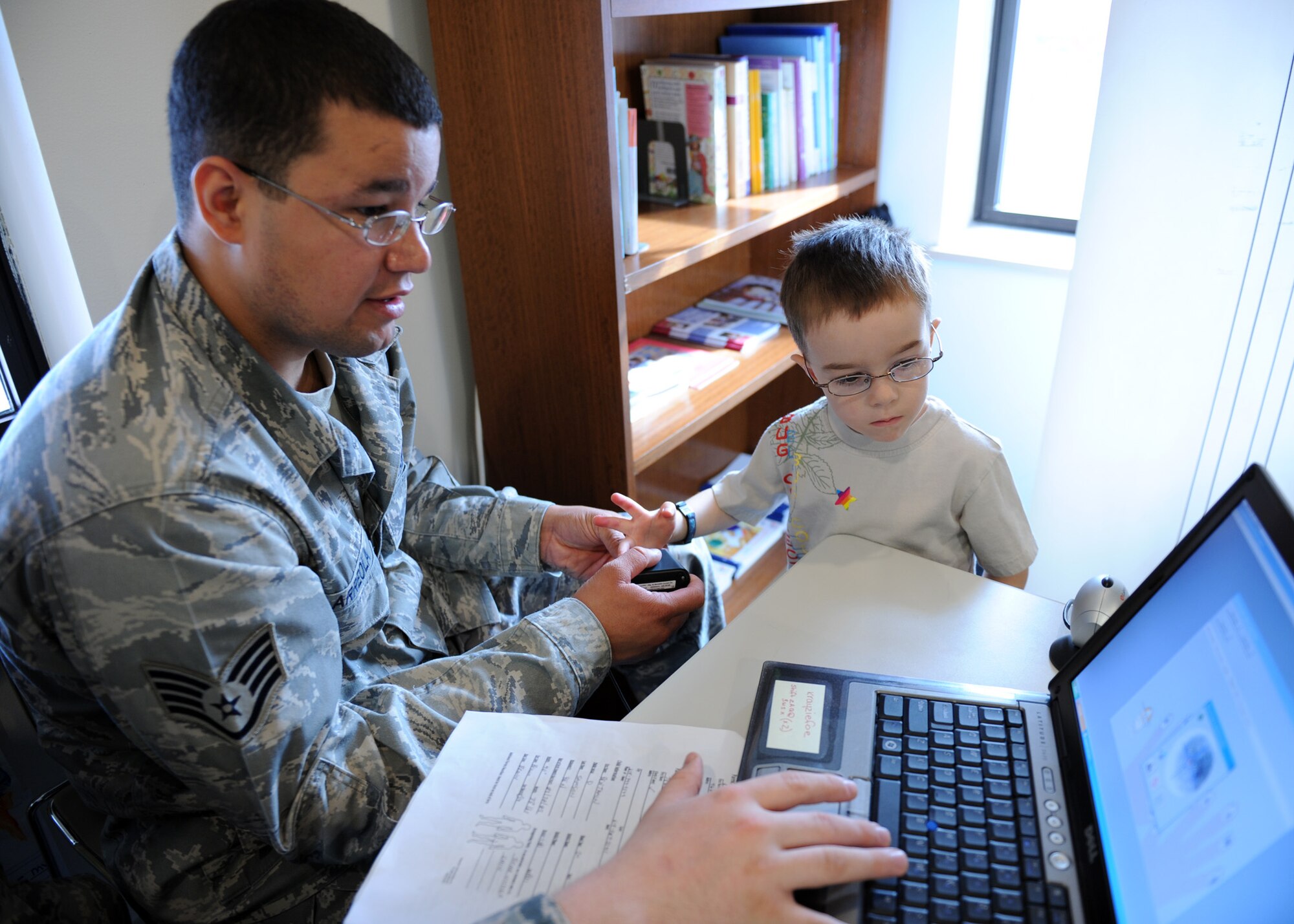 SCOTT AIR FORCE BASE, Ill. --Staff Sgt. David Arreola, Police Services NCOIC, takes Ben Samson’s fingerprints digitally at the Child Development Center. Security Forces spent two days loading information so parents have their child’s information recorded for safety purposes and are able to update it regularly.(U.S. Air Force photo/Staff Sgt. Paul Villanueva II) 