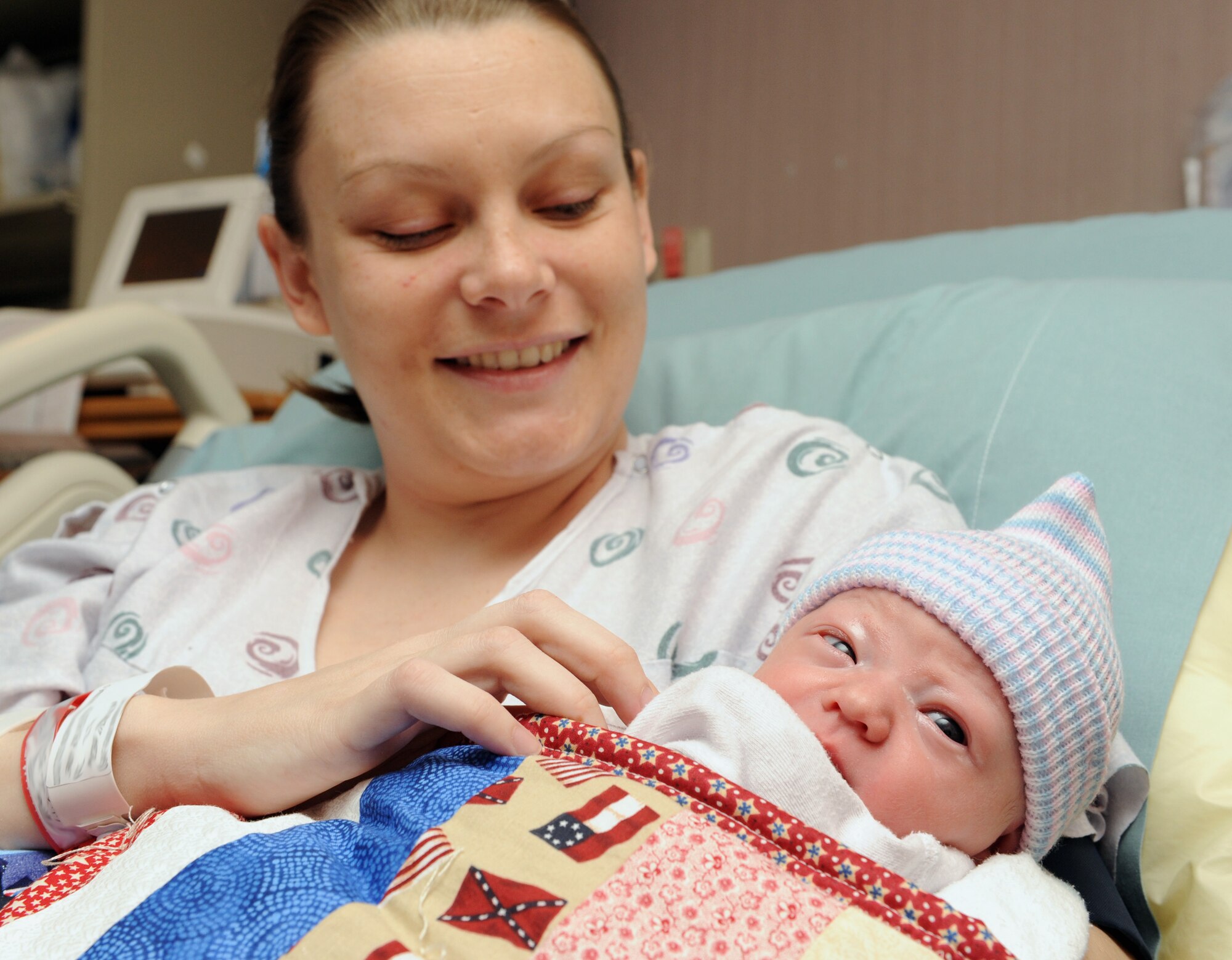MOUNTAIN HOME AIR FORCE BASE, Idaho - New mother, Dena Norwood, looks down at her new-born baby, Kirsten Charolette Norwood, at the base hospital March 24 after receiving the 1,000th Hammond Baby Bundle. Each baby bundle contains a handmade quilt and card made by base and local volunteers along with clothing, a stuffed animal and hat. Every baby born at the base hospital receives a bundle with each one numbered and tracked.  (U.S. Air Force photo by Airman 1st Class Debbie Lockhart)
